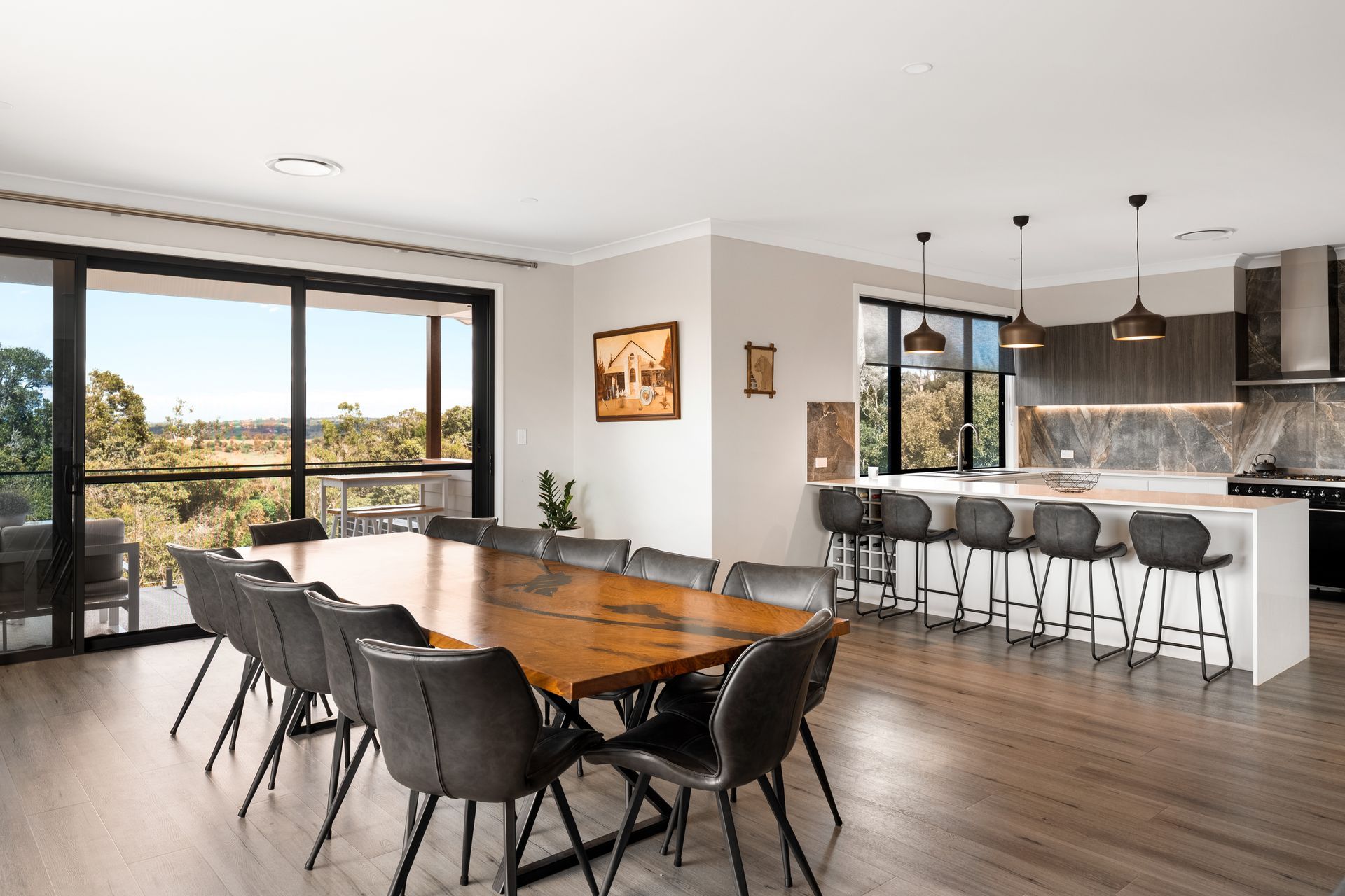a dining room with a large wooden table and chairs and a kitchen .