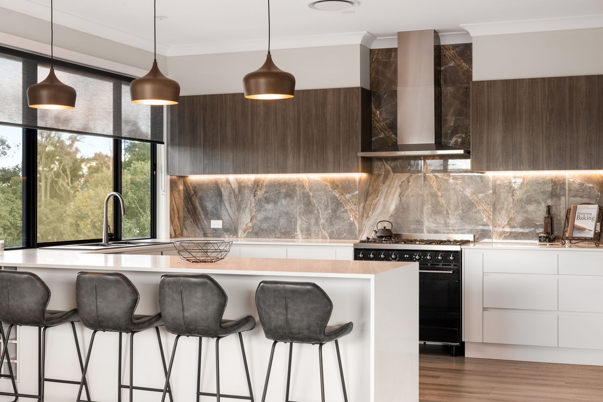 a kitchen with a large island , stools and a stove .