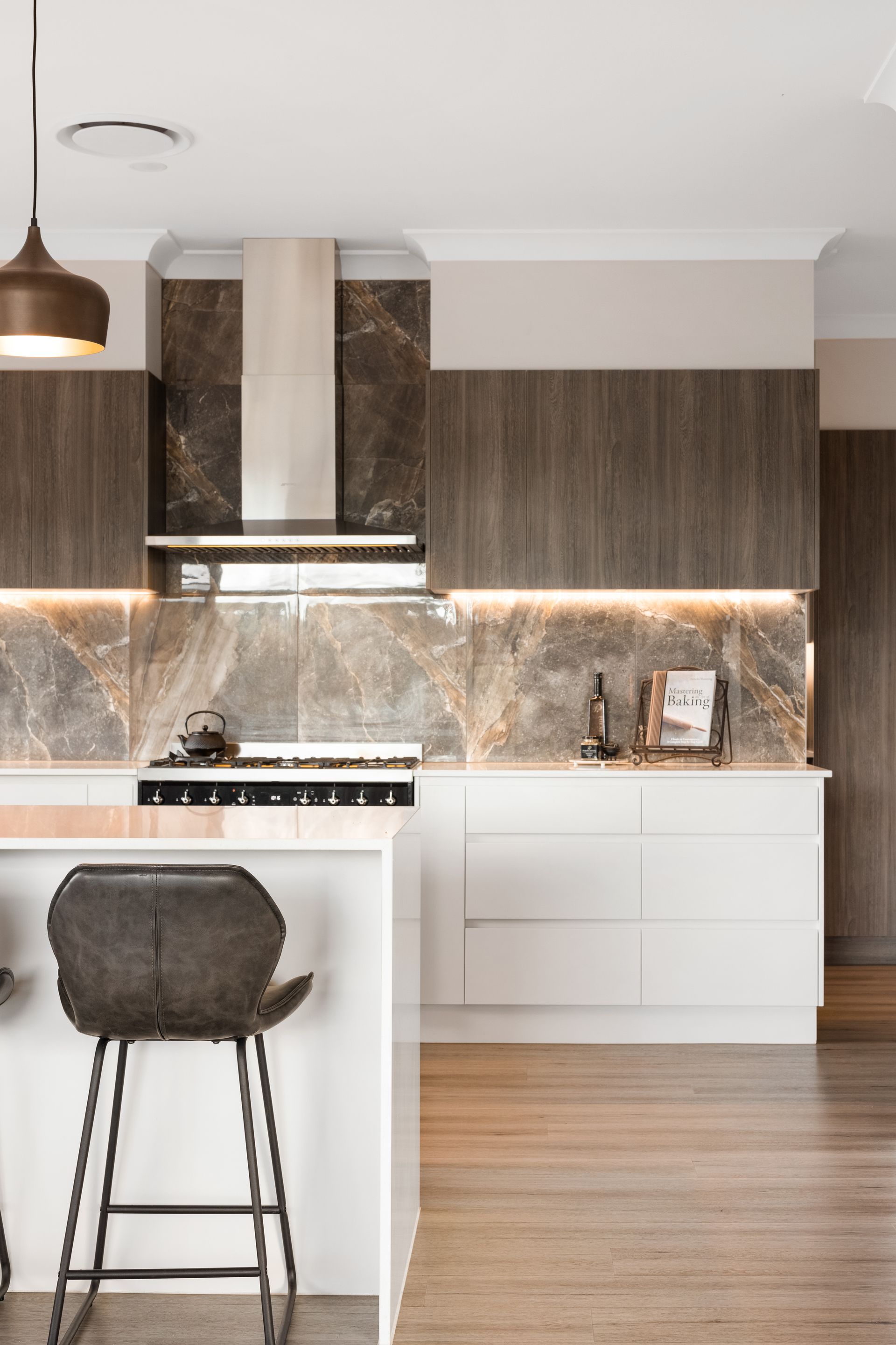 a kitchen with white cabinets and wooden floors and a stove top oven .