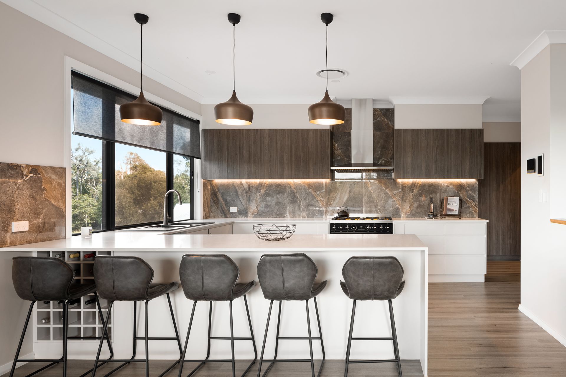 a kitchen with a large island , stools and a stove .
