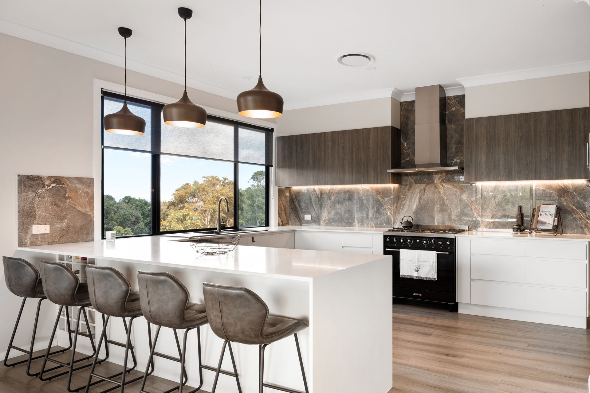 a kitchen with a large island , stools and a stove .