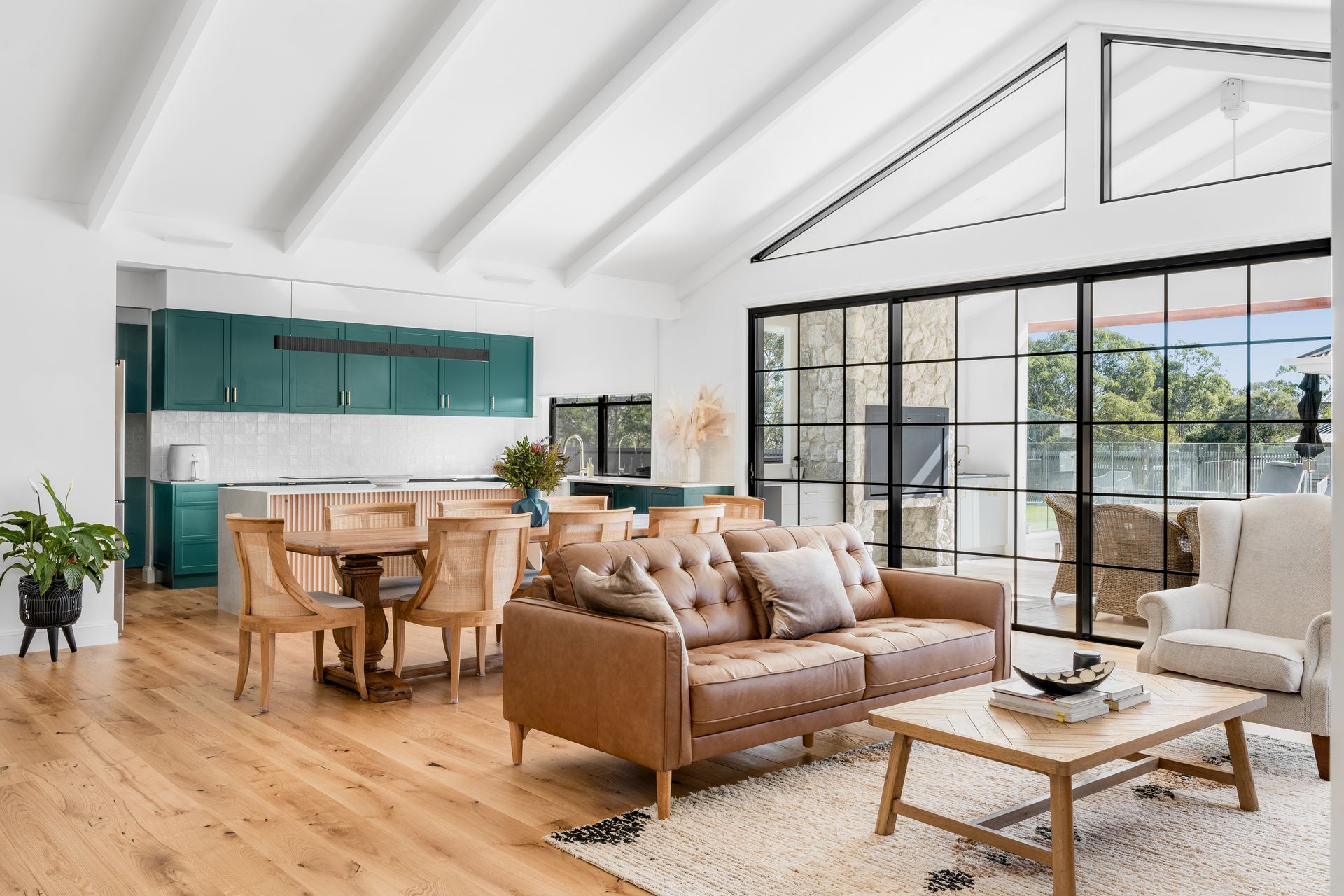 a living room with a couch , table , chairs and sliding glass doors .