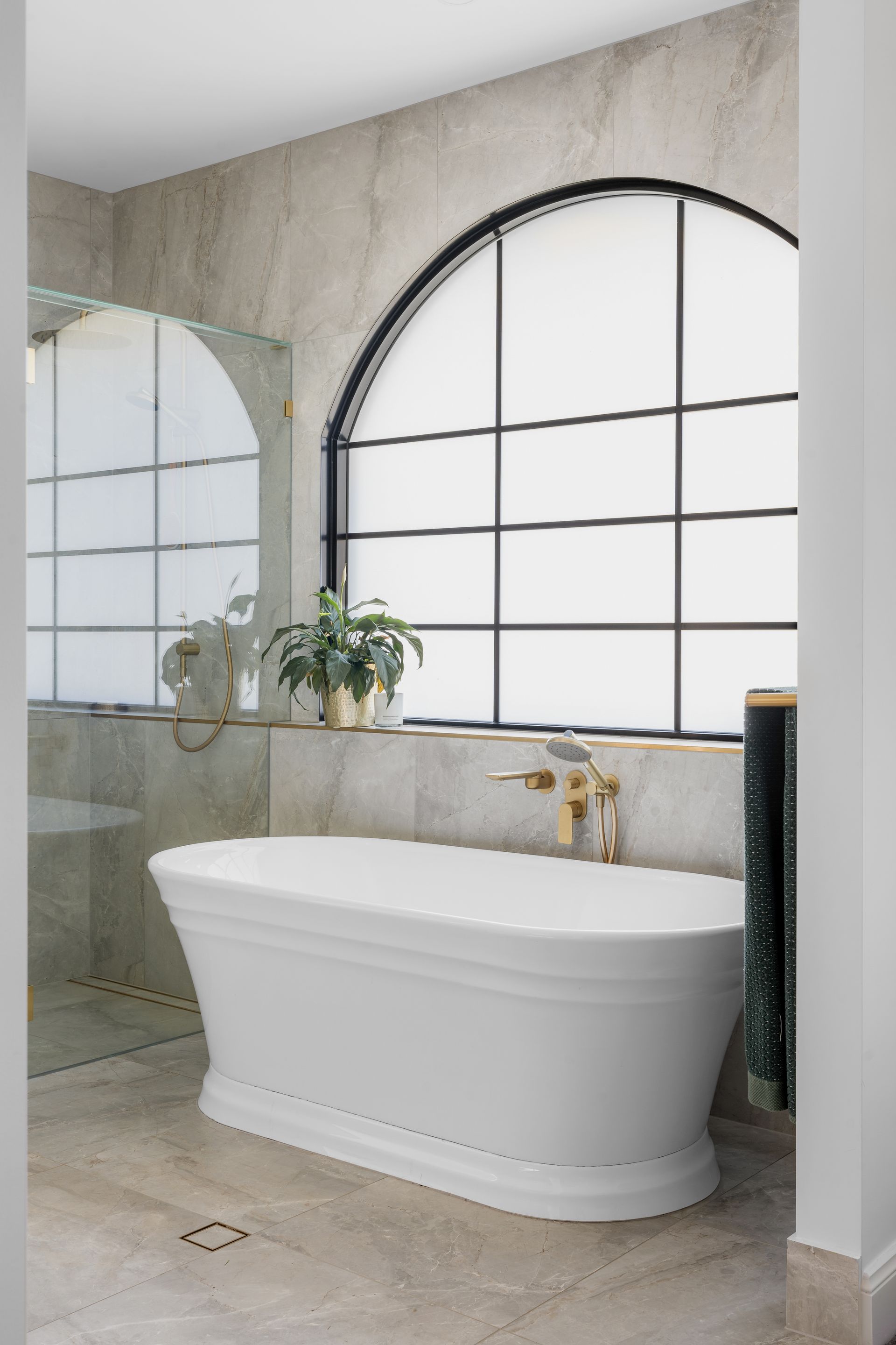 a bathroom with a bathtub and a large window .