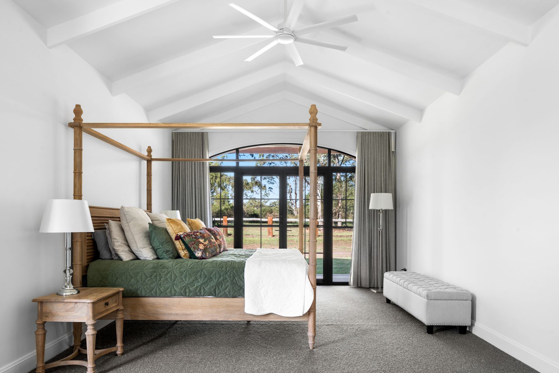 a bedroom with a canopy bed and a ceiling fan .