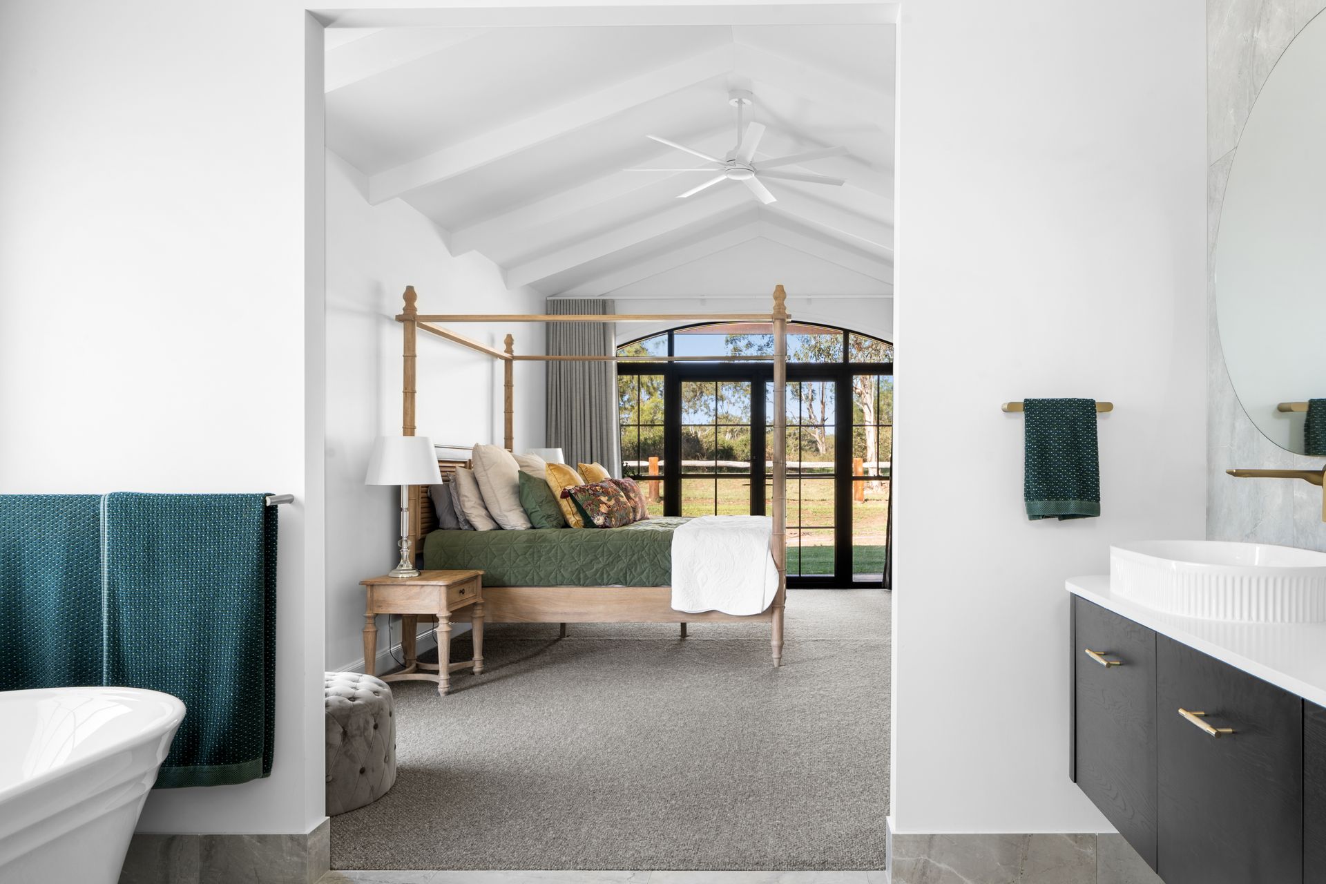 a bedroom with a canopy bed and a bathroom with a sink .