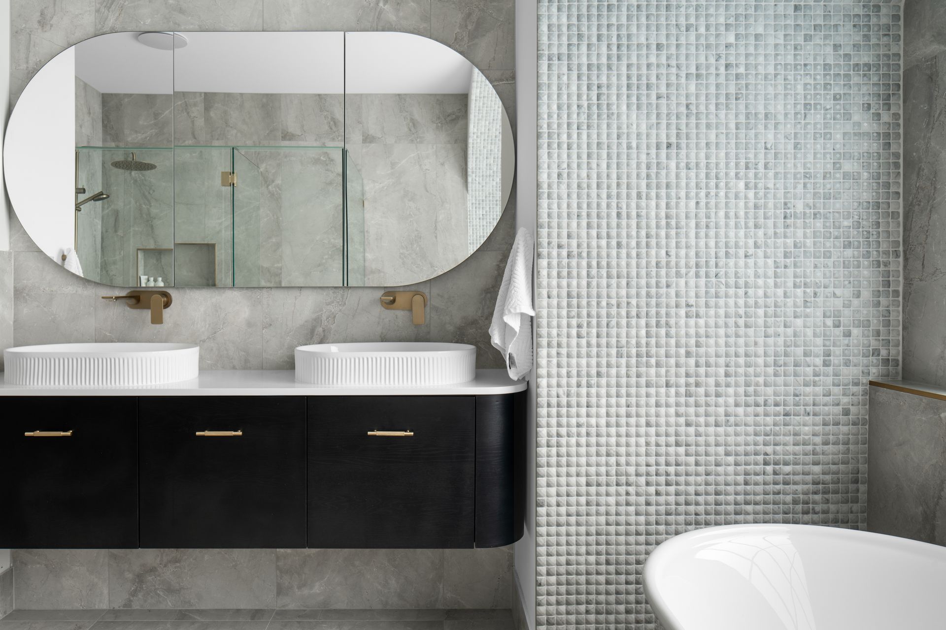 a bathroom with two sinks , a large mirror and a bathtub .
