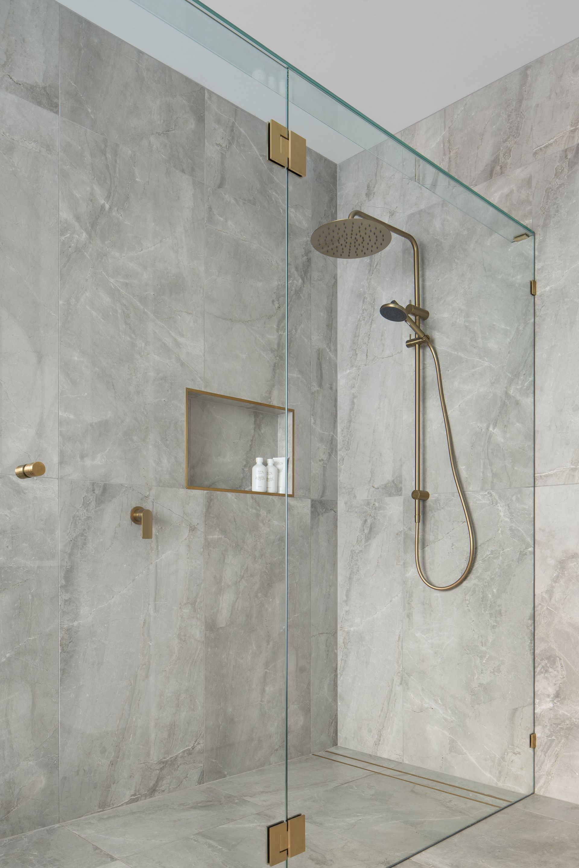 a walk in shower with a glass door and a shower head .