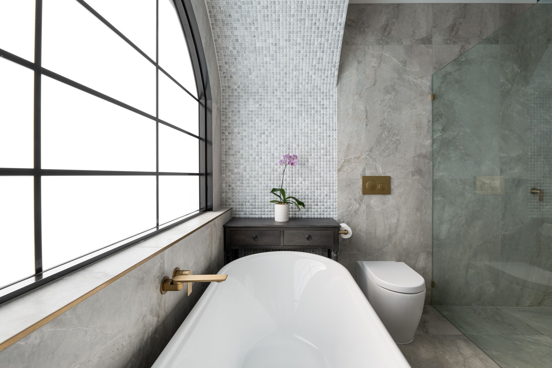 a bathroom with a bathtub , toilet , and window .