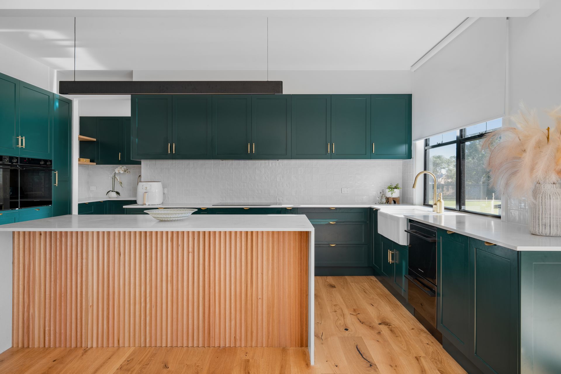 a kitchen with green cabinets and a wooden island .