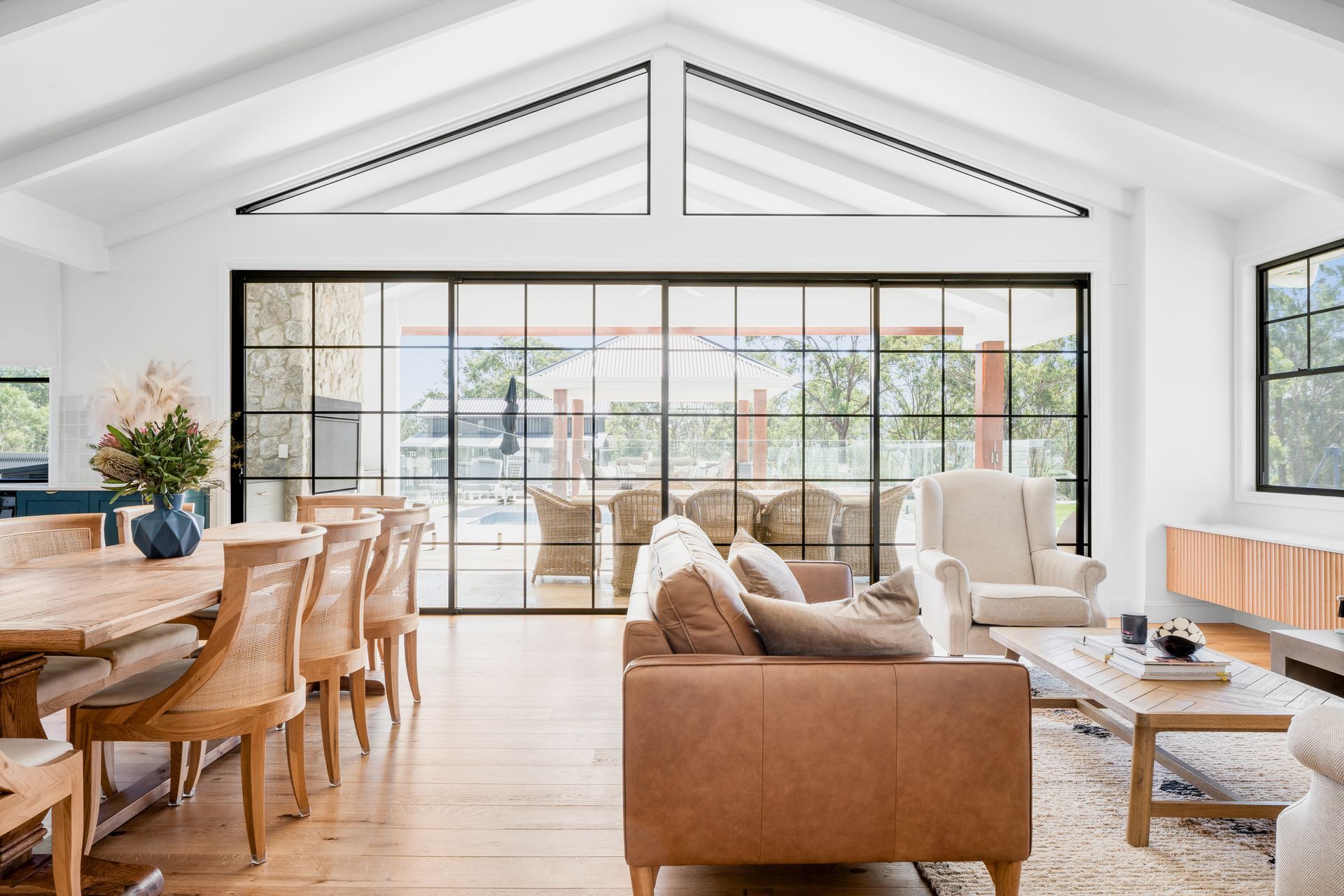 a living room with a couch , table , chairs and sliding glass doors .