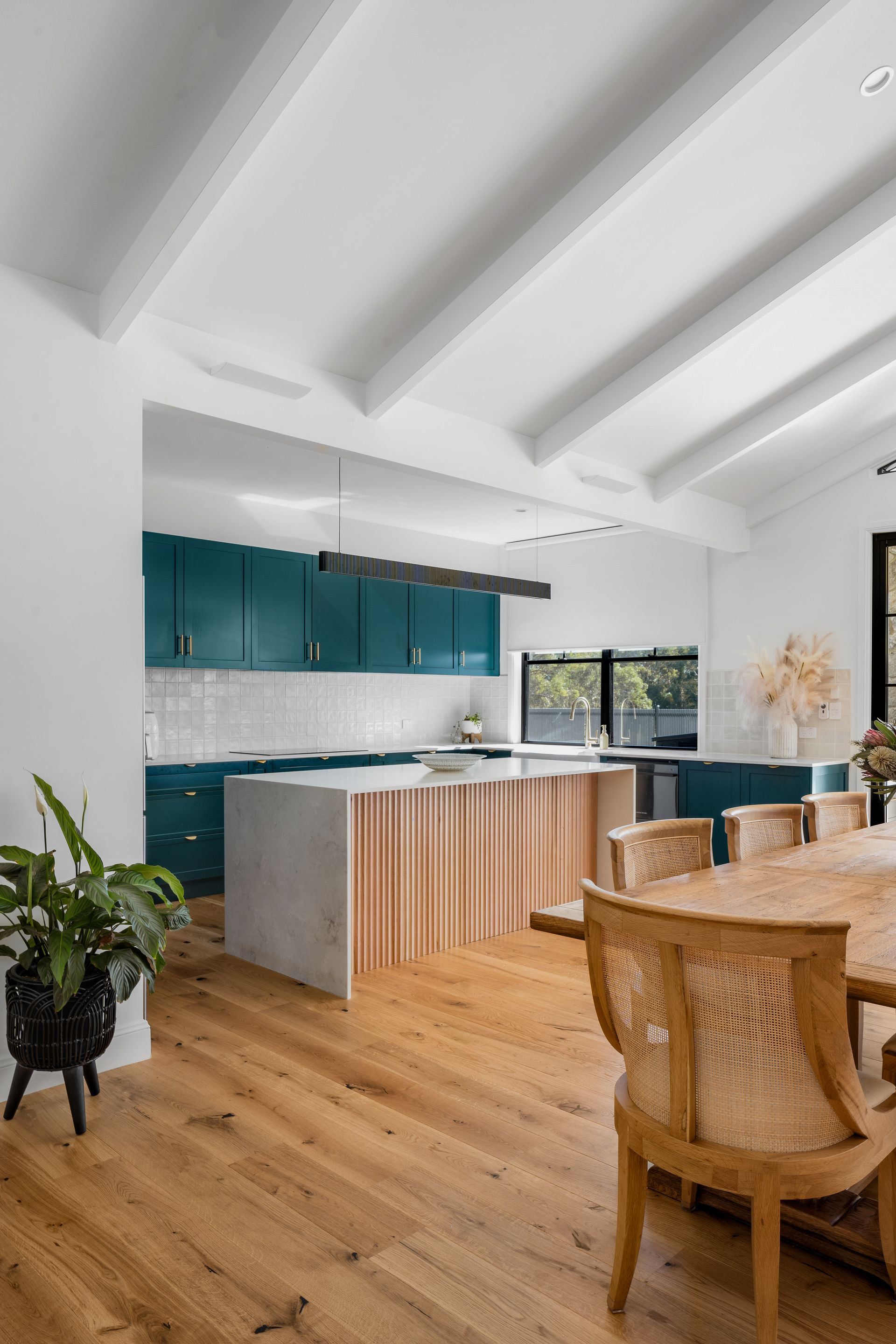 a kitchen and dining room in a house with a wooden table and chairs .