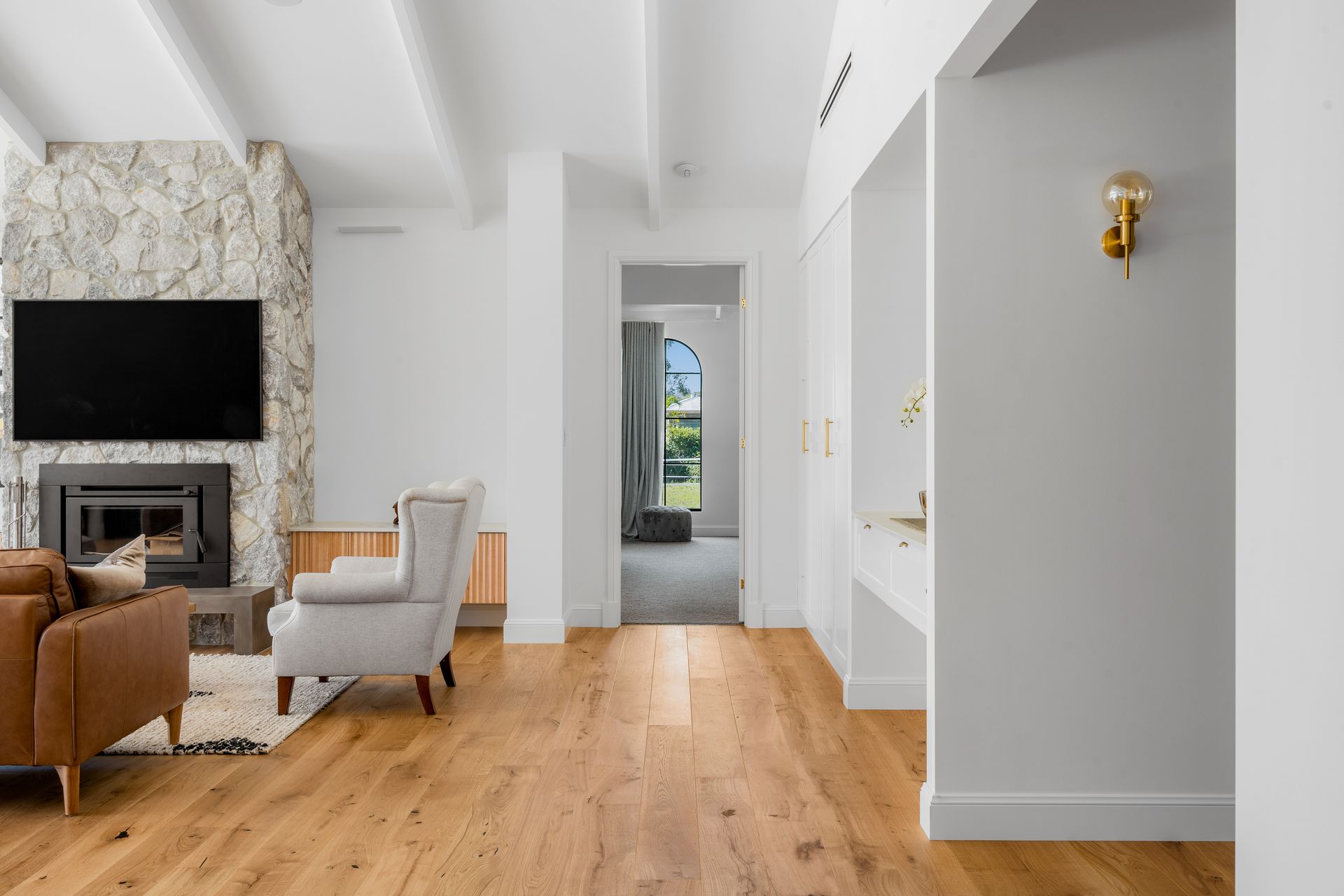 a living room with hardwood floors , a fireplace and a flat screen tv .