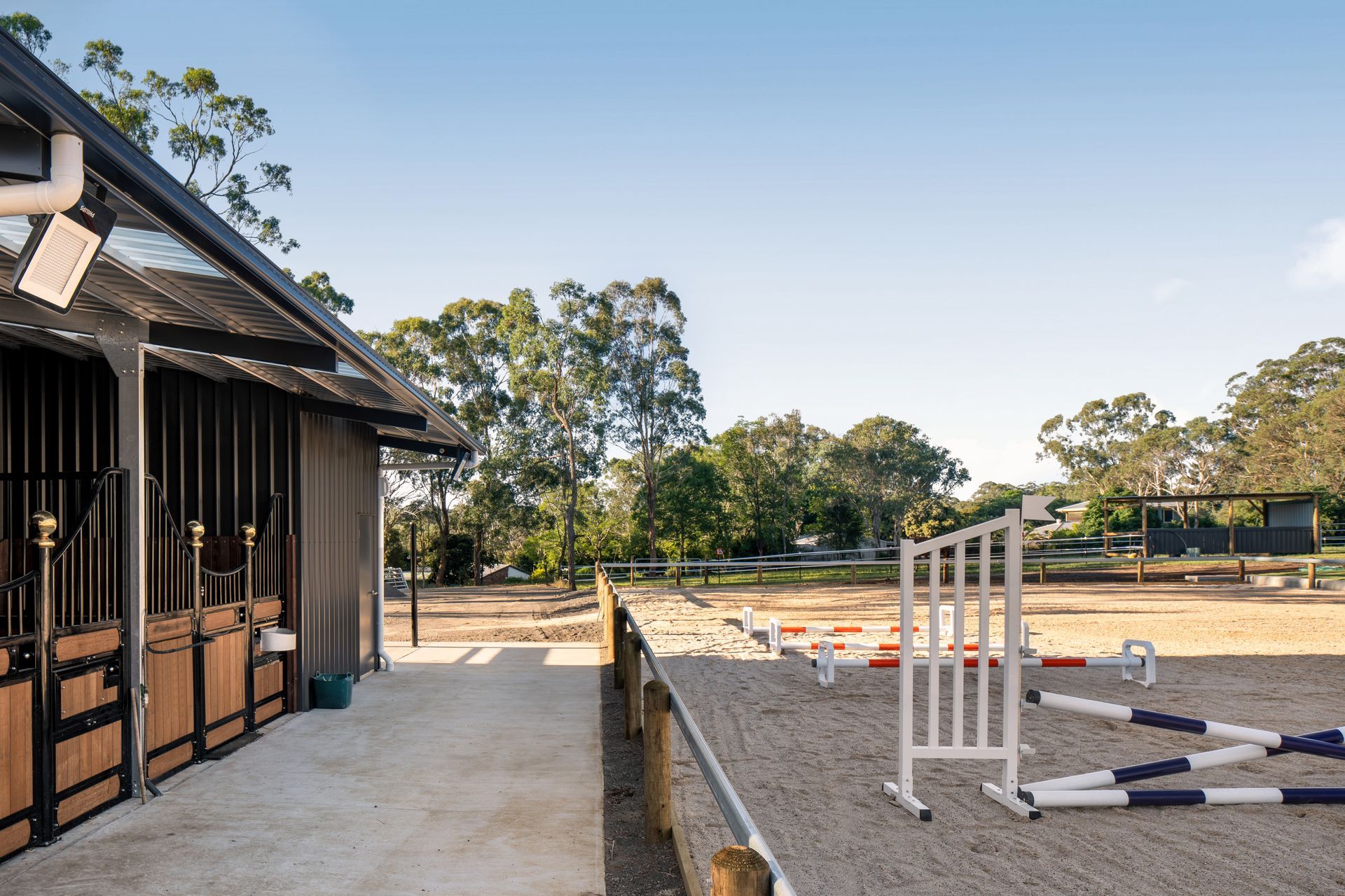 a horse stable with a jumping fence in the middle of it .