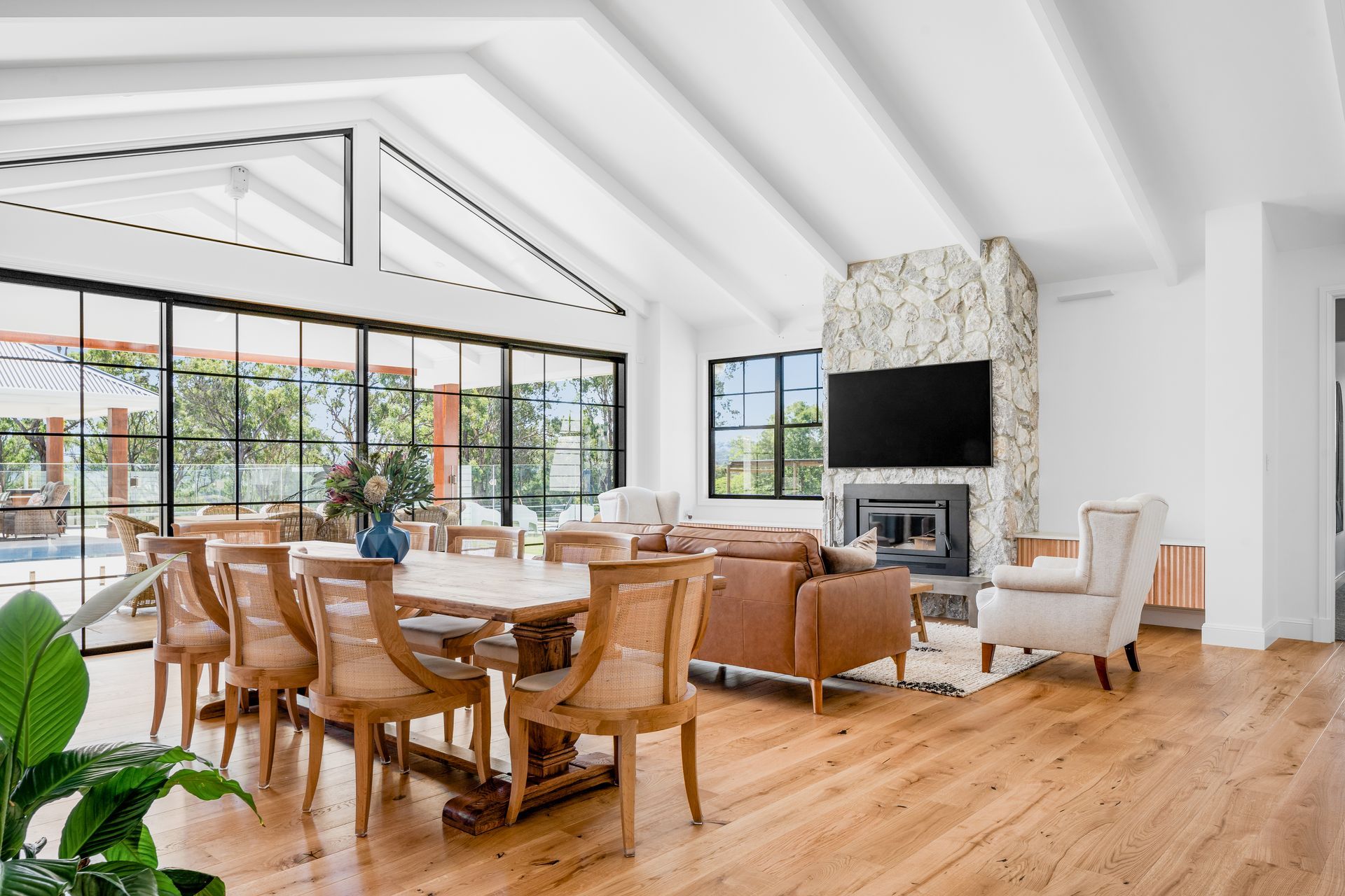a living room with a dining table , chairs , a couch and a fireplace