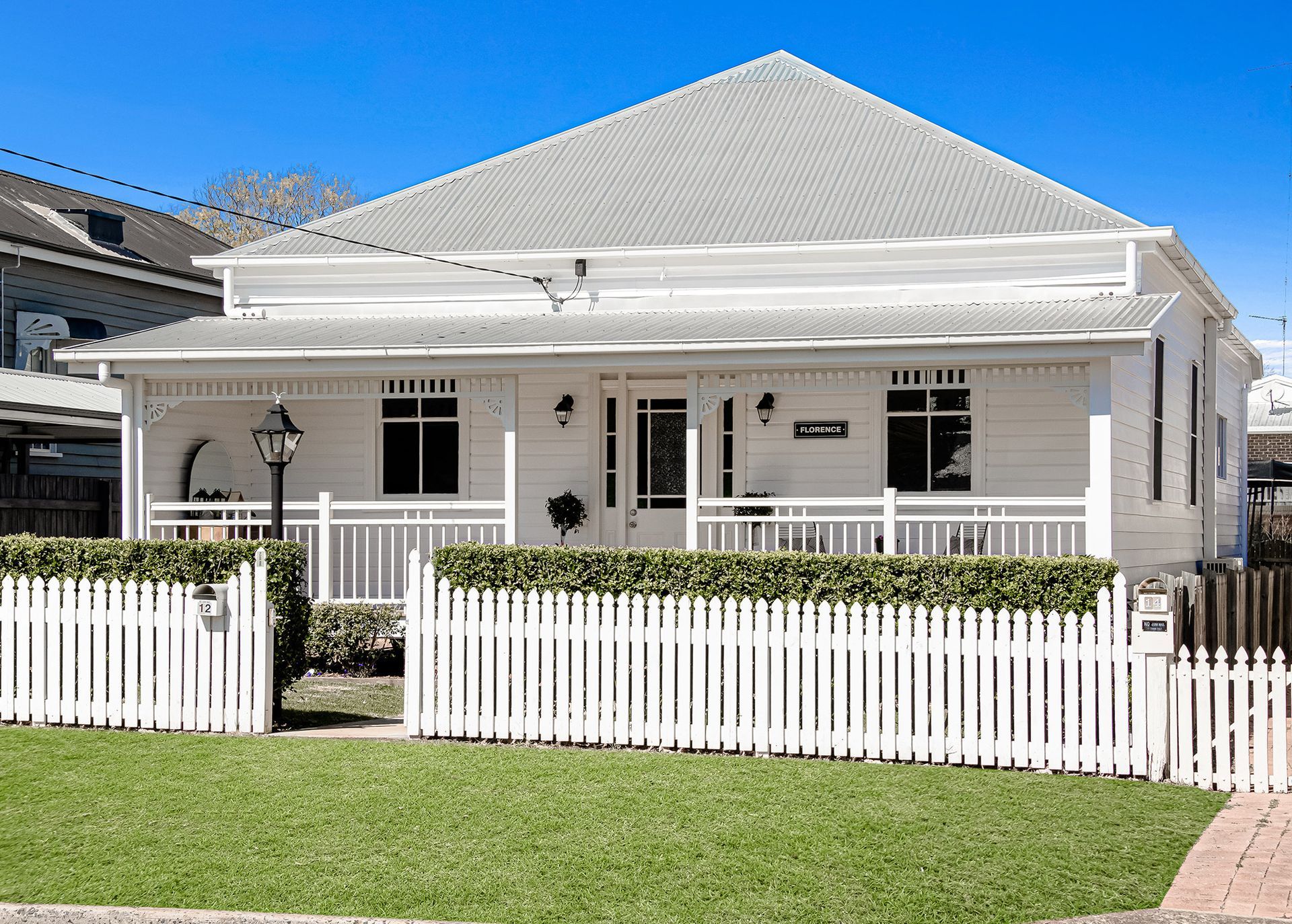 a white house with a white picket fence in front of it .