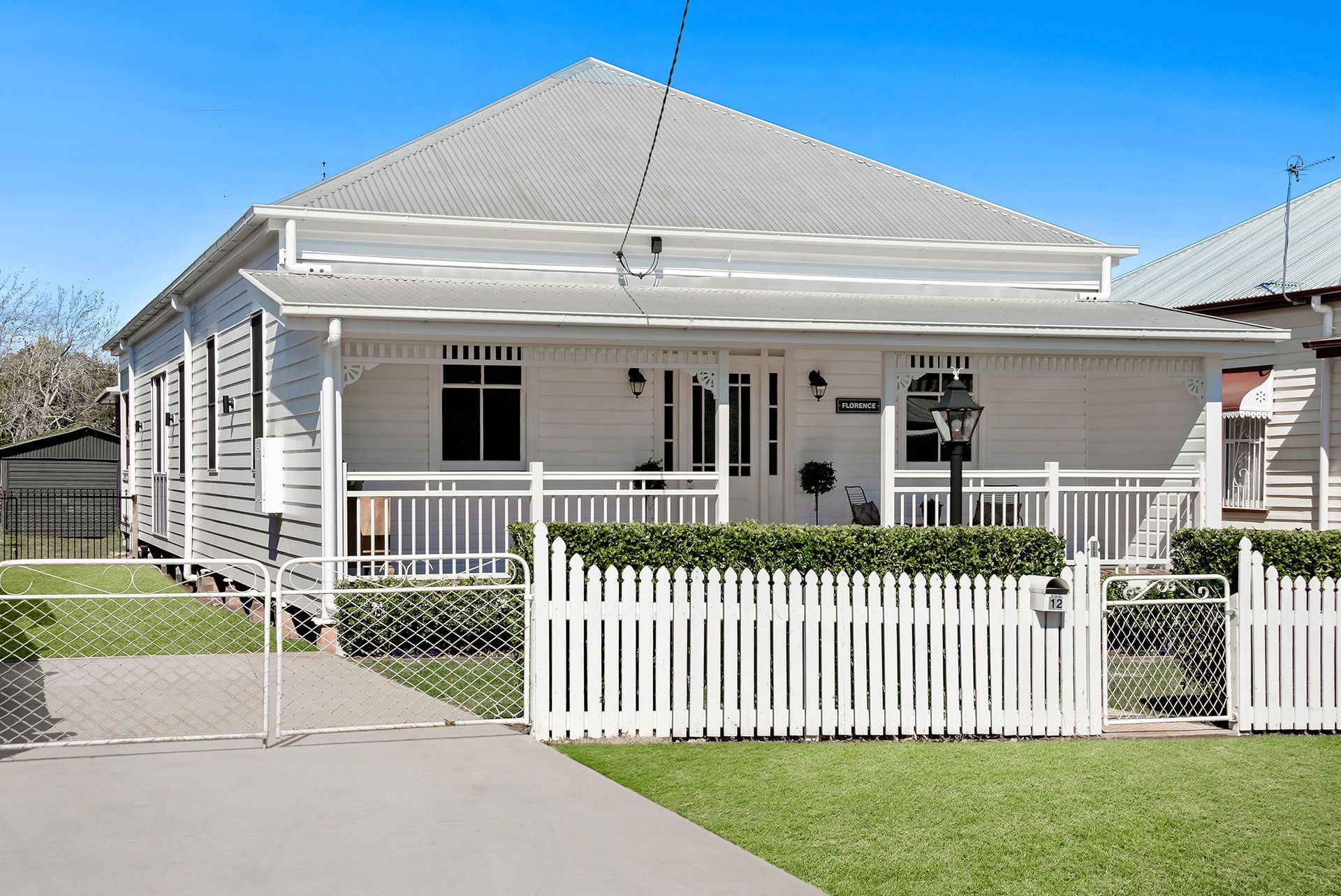 a white house with a white picket fence in front of it .