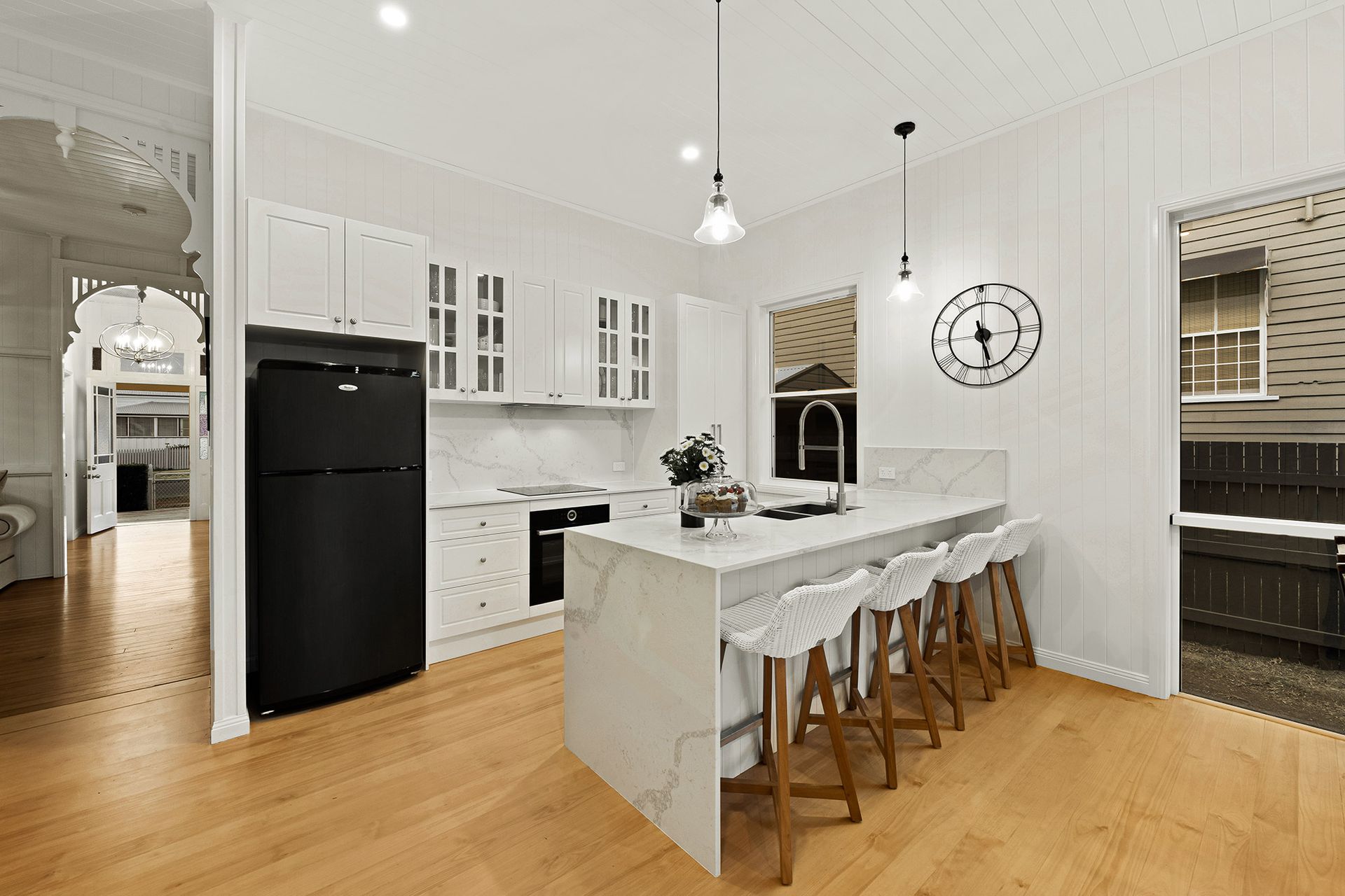 a kitchen with white cabinets and a black refrigerator .