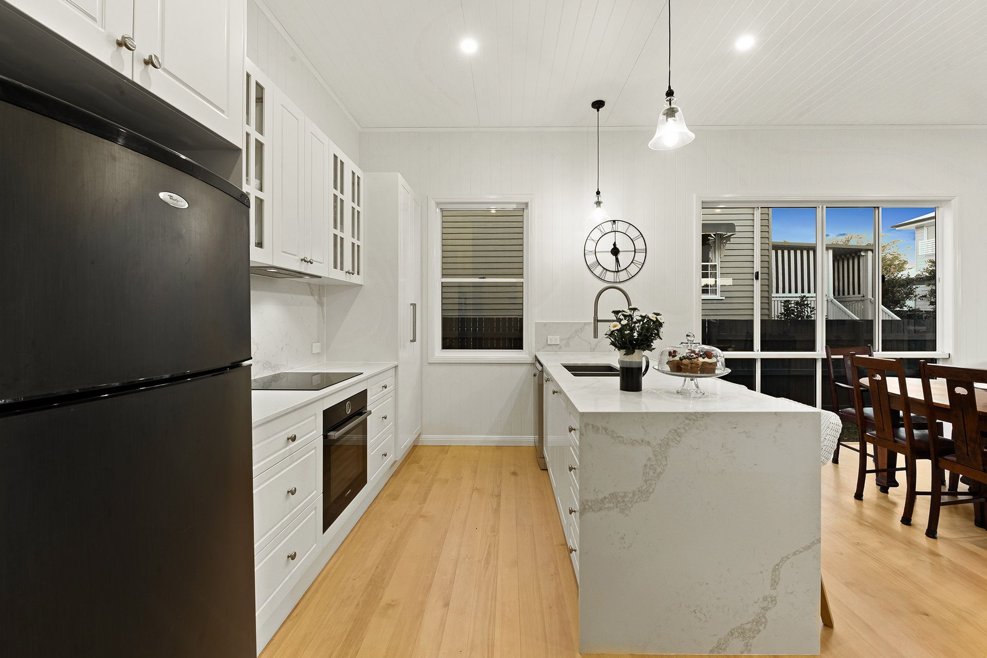 a kitchen with white cabinets and a black refrigerator .