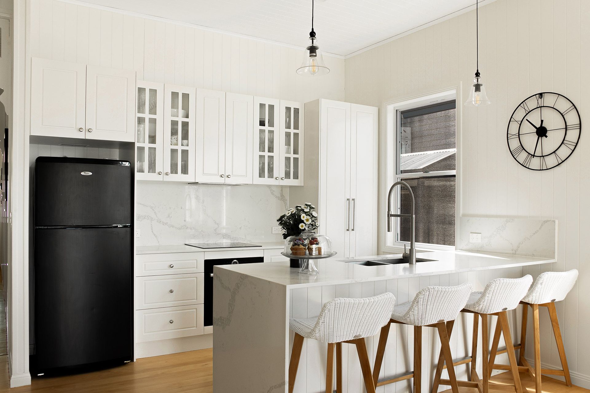 a kitchen with white cabinets and a black refrigerator .