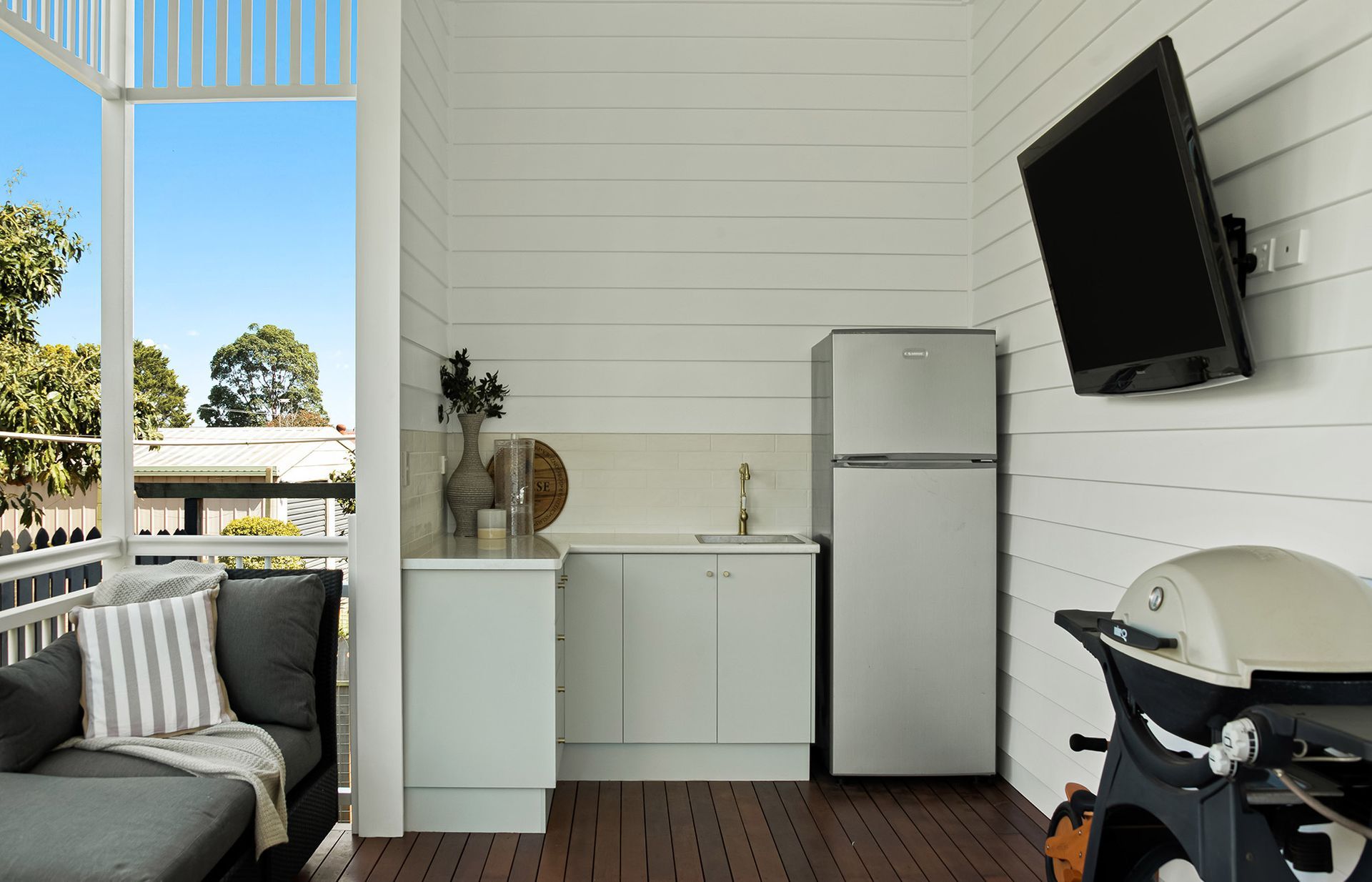 a kitchen with a refrigerator , sink , and television .