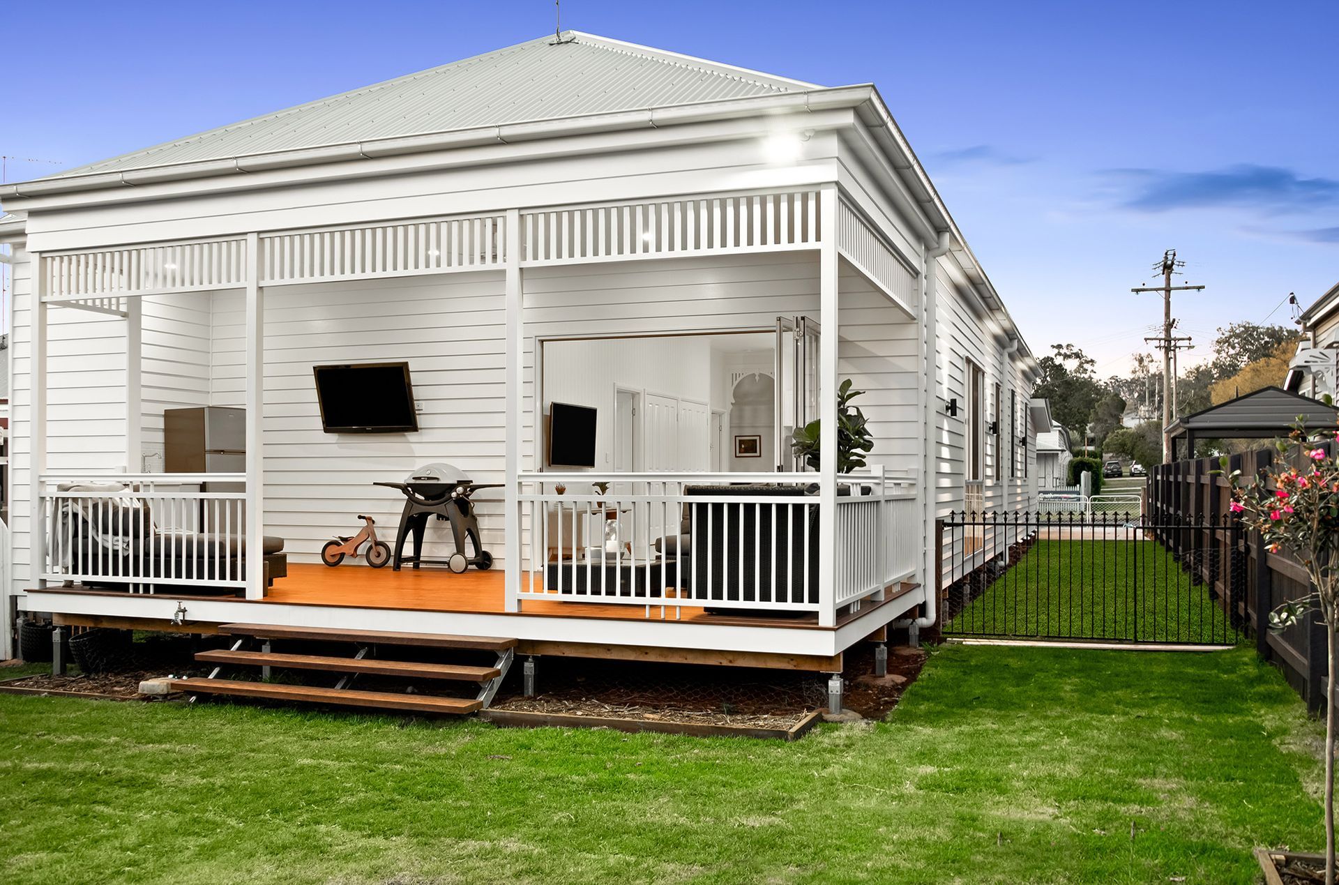 a white house with a porch and a television on it