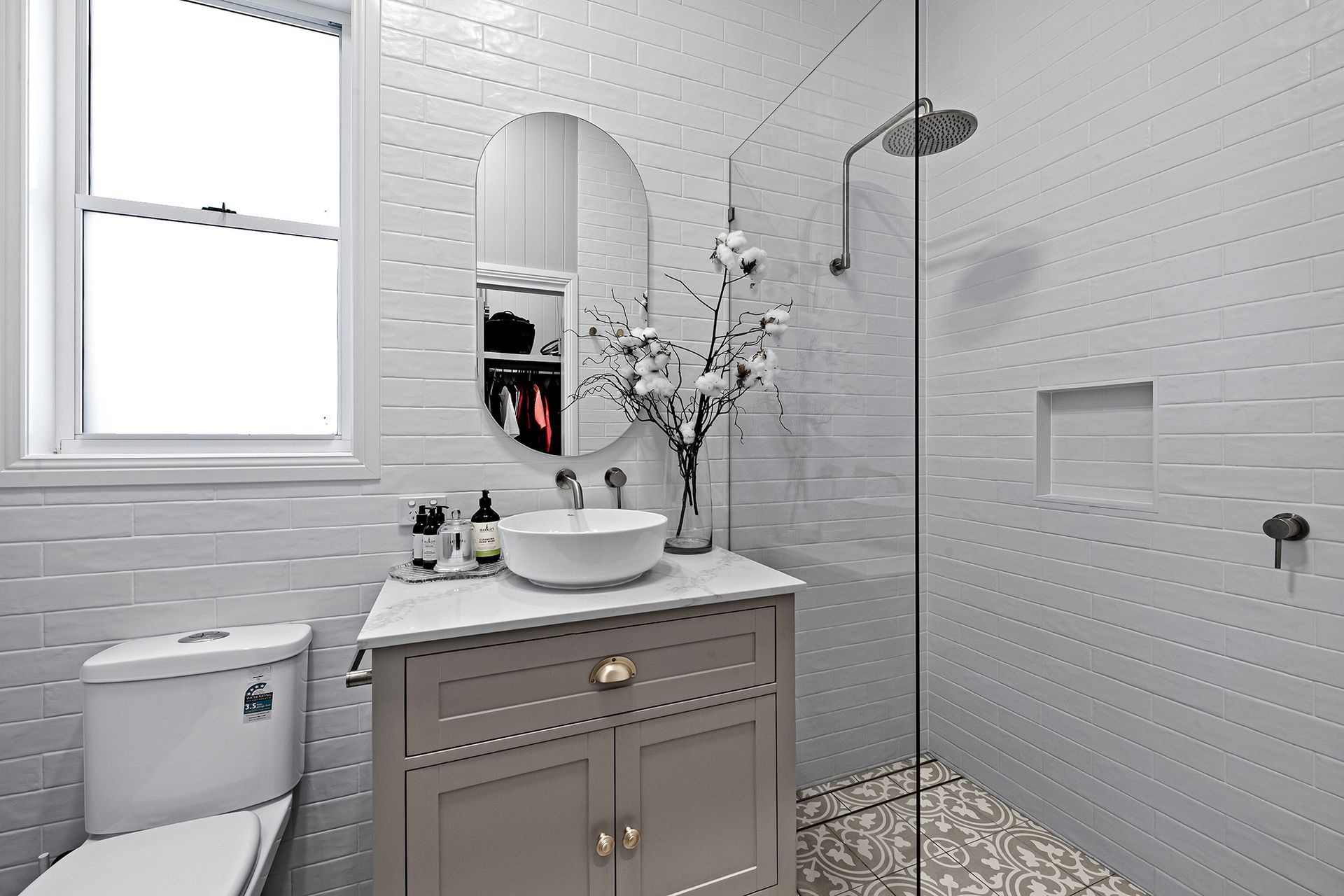 a bathroom with a toilet , sink , mirror and walk in shower .