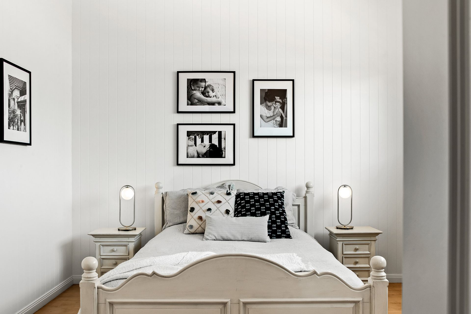 a bedroom with a bed , nightstands , and pictures on the wall .