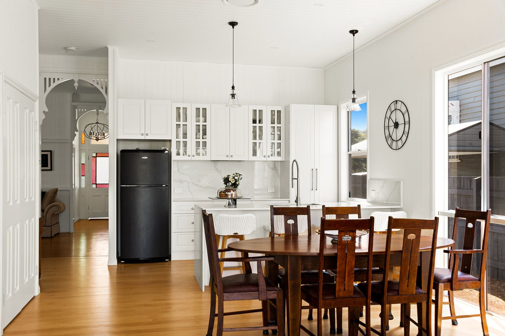 a kitchen with a table and chairs and a black refrigerator