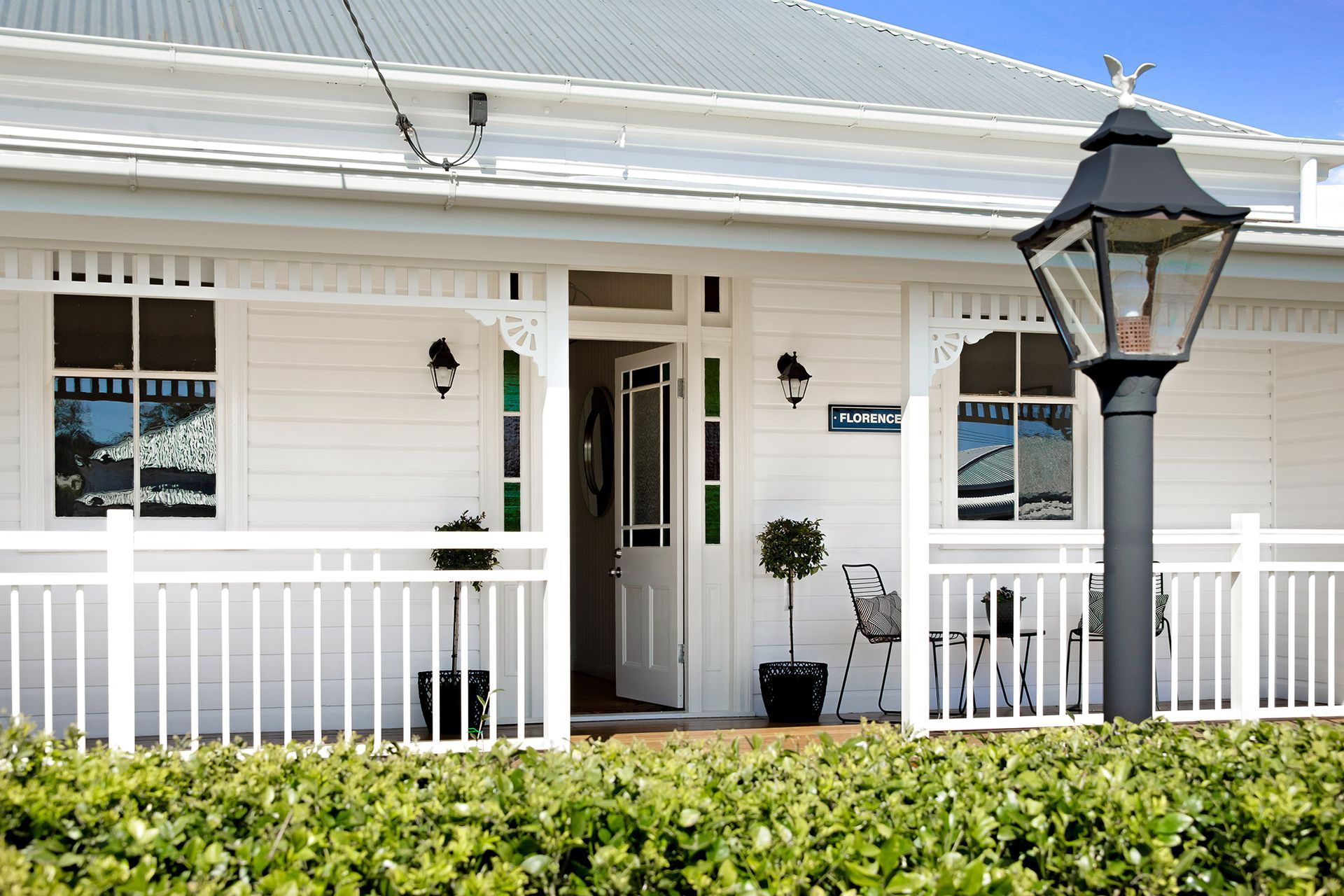 a white house with a porch and a lamp post