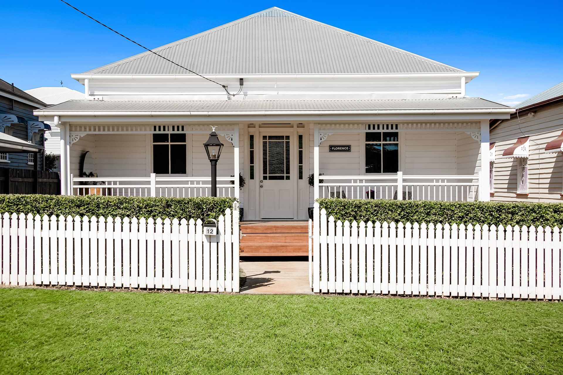 a white house with a white picket fence in front of it .