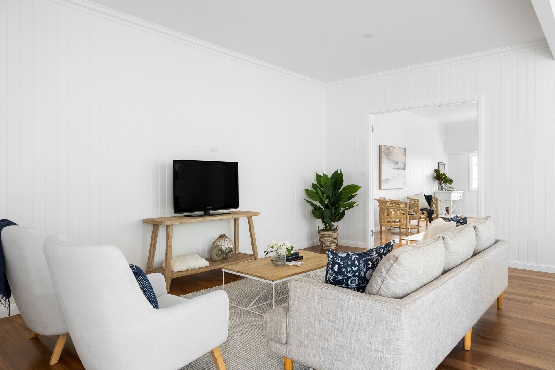 a living room with a couch , chairs , and a flat screen tv .