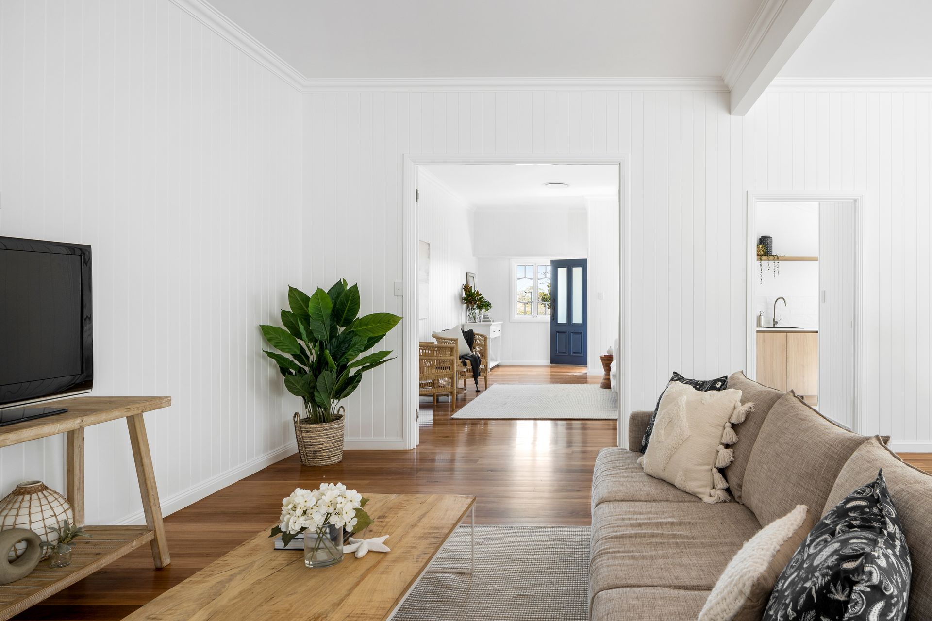 a living room with a couch , coffee table , and television .