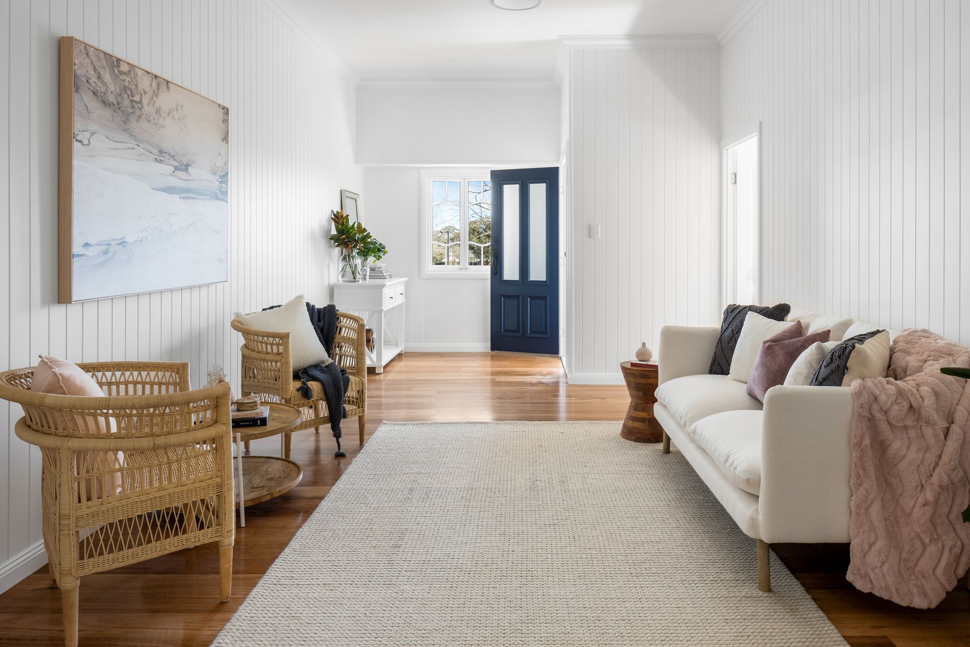 a living room with a couch , chairs , and a rug .
