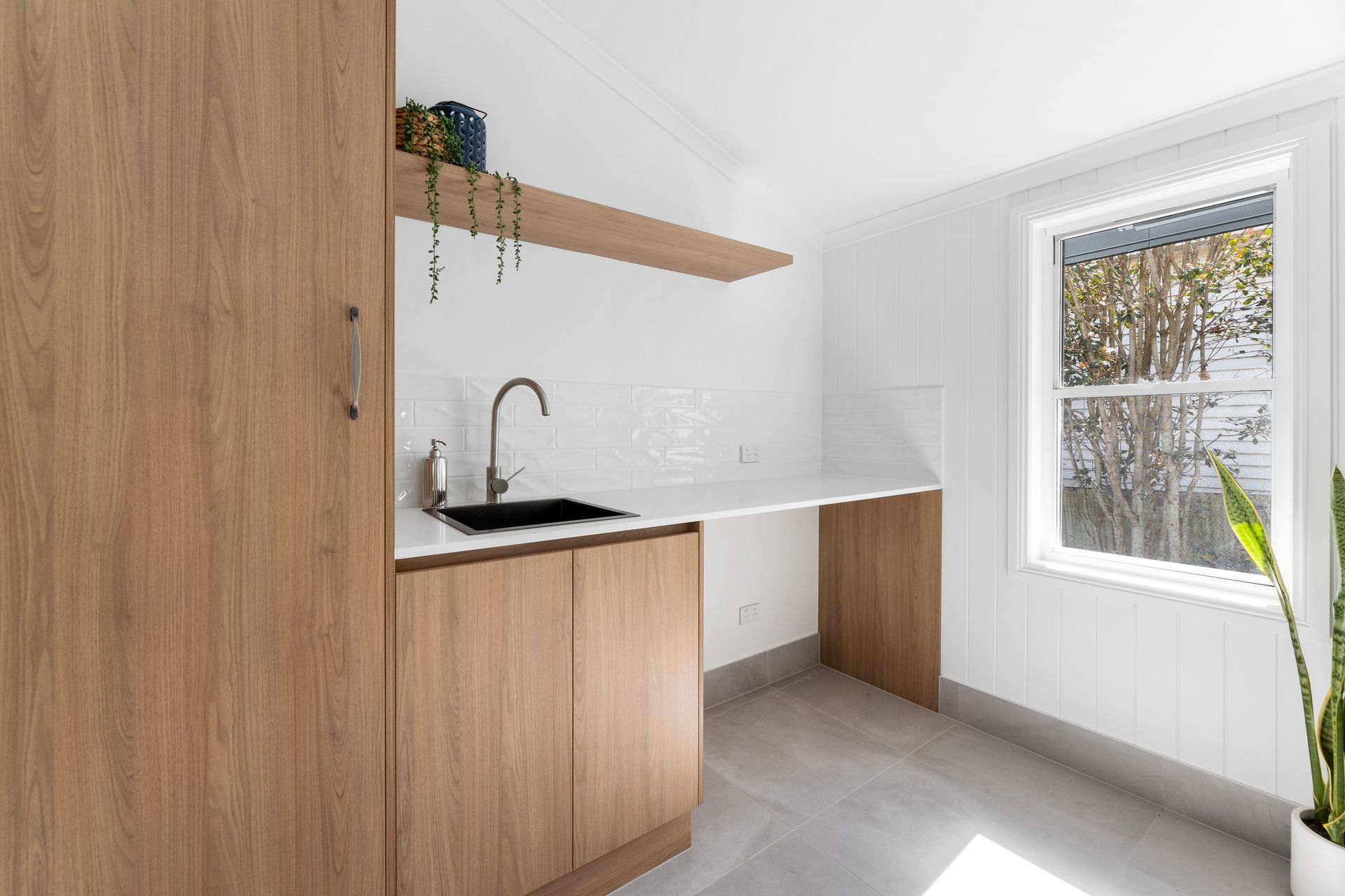 a kitchen with wooden cabinets , a sink , and a window .