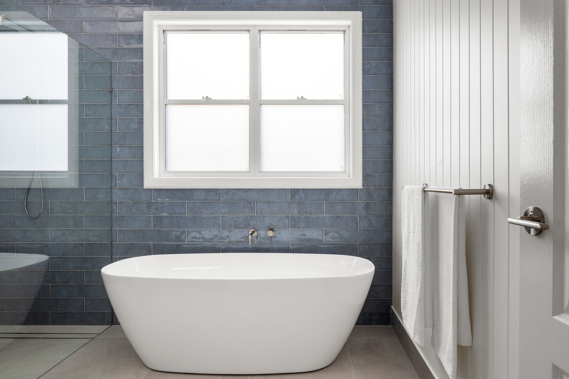a bathroom with a bathtub , toilet , and window .