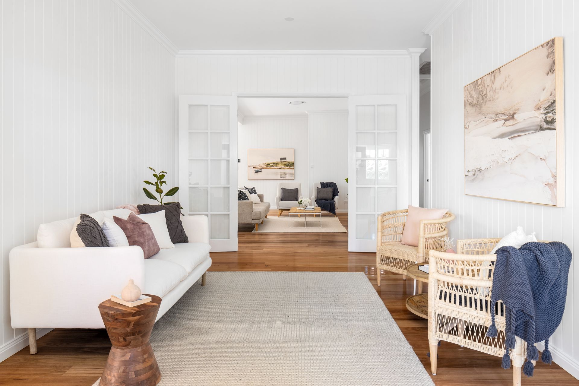 a living room with a couch , chair , rug and sliding glass doors .