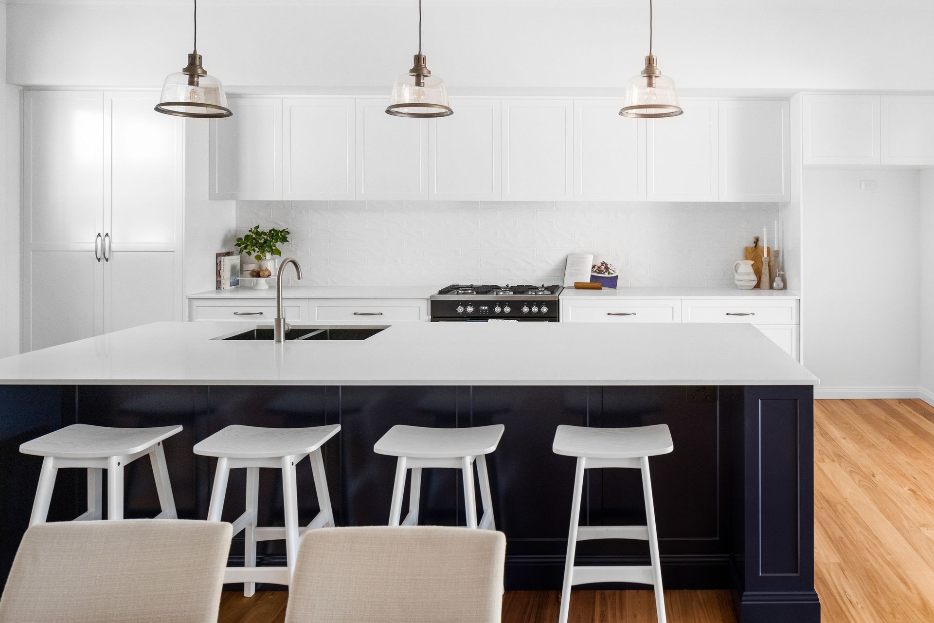 a kitchen with a large island , stools , chairs and a stove .