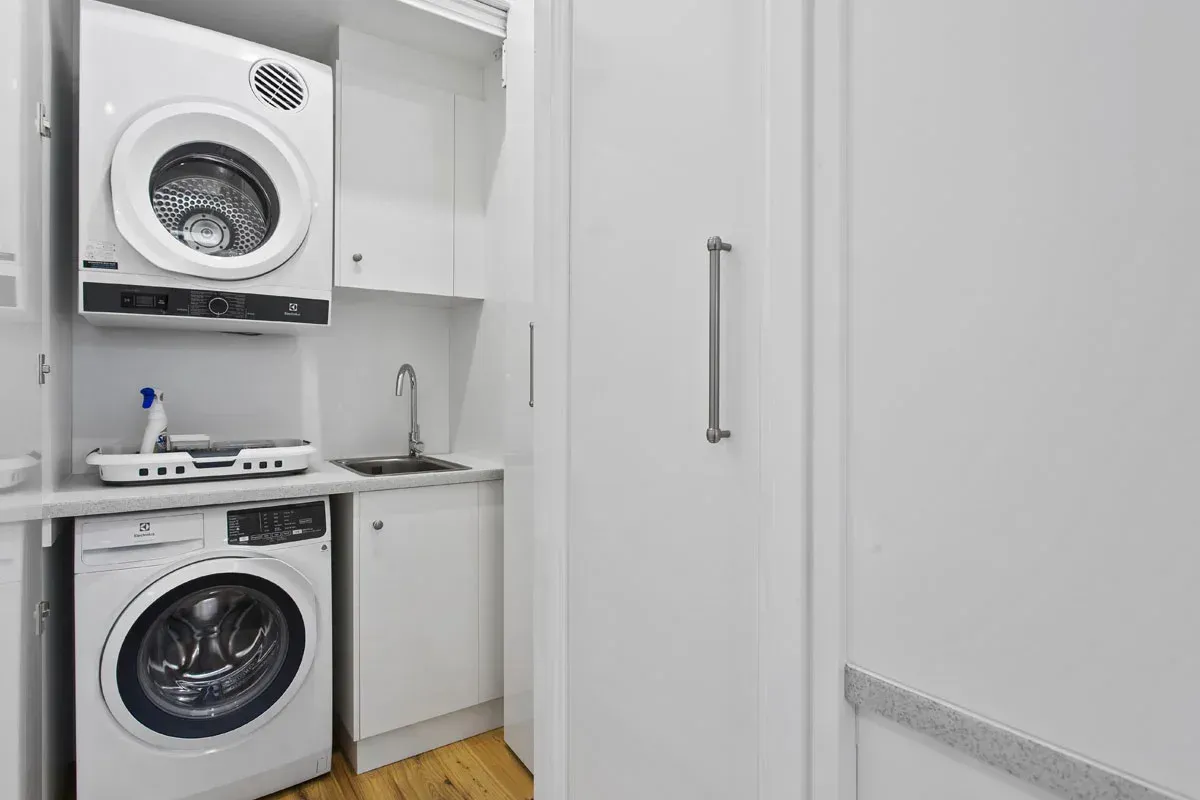 a laundry room with a washer and dryer stacked on top of each other .