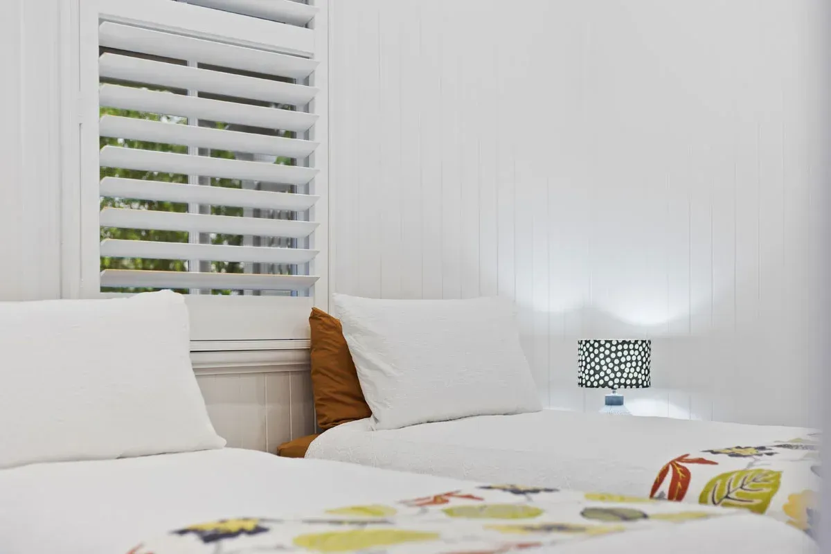 a bedroom with two beds and a lamp .