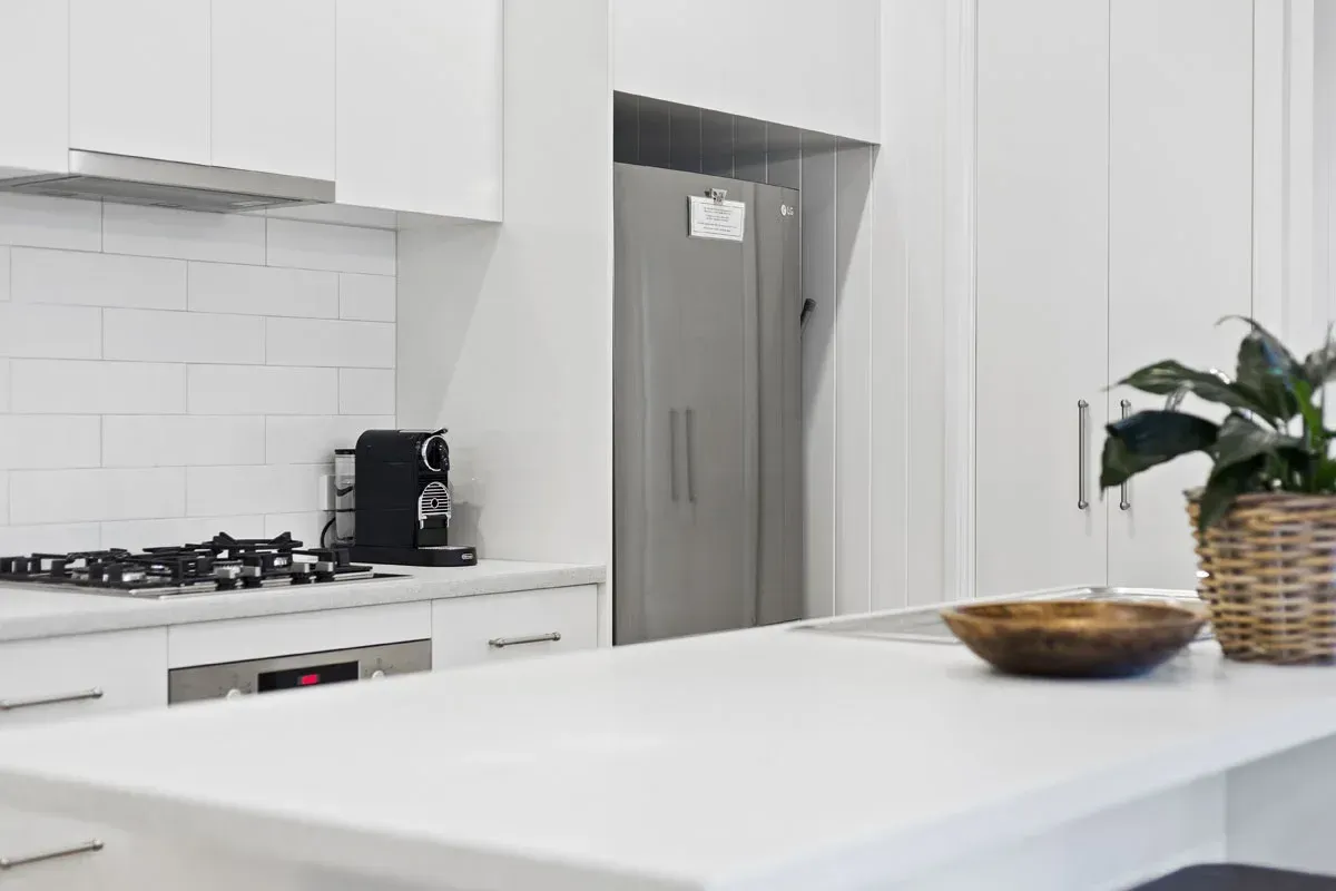 a kitchen with white cabinets and a stainless steel refrigerator .