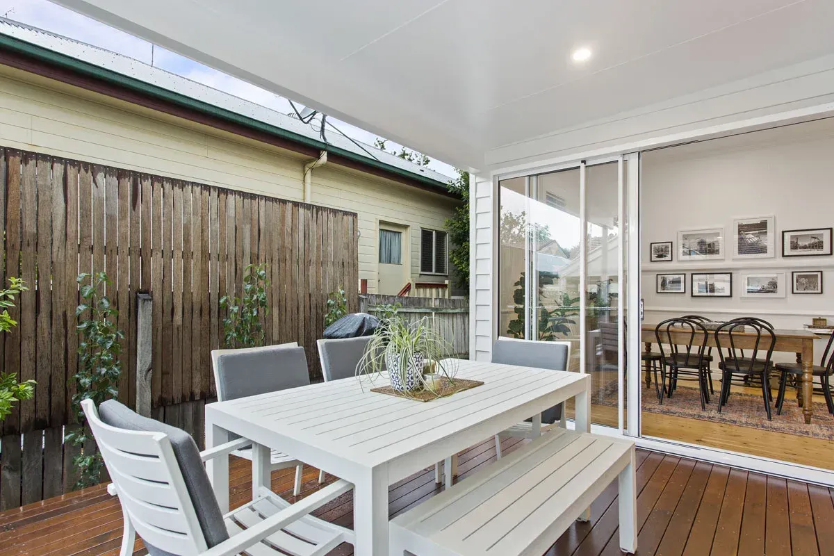 a patio with a table and chairs and a sliding glass door .