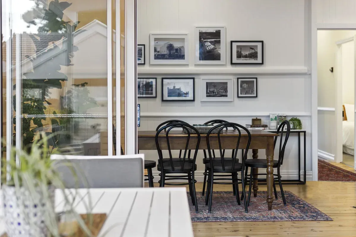a dining room with a table and chairs and pictures on the wall .