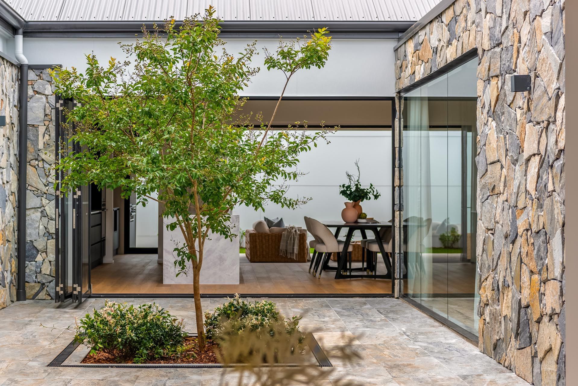 There is a tree in the middle of the courtyard of a house.