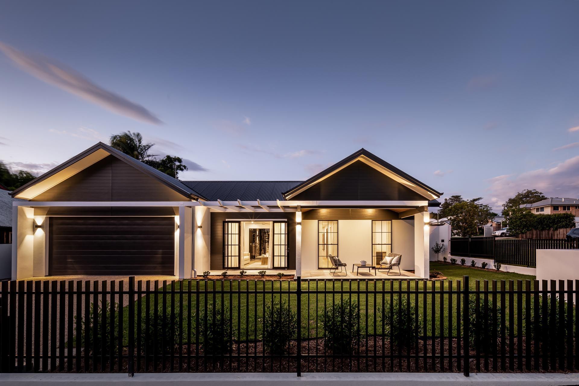 The front of a house with a black fence around it