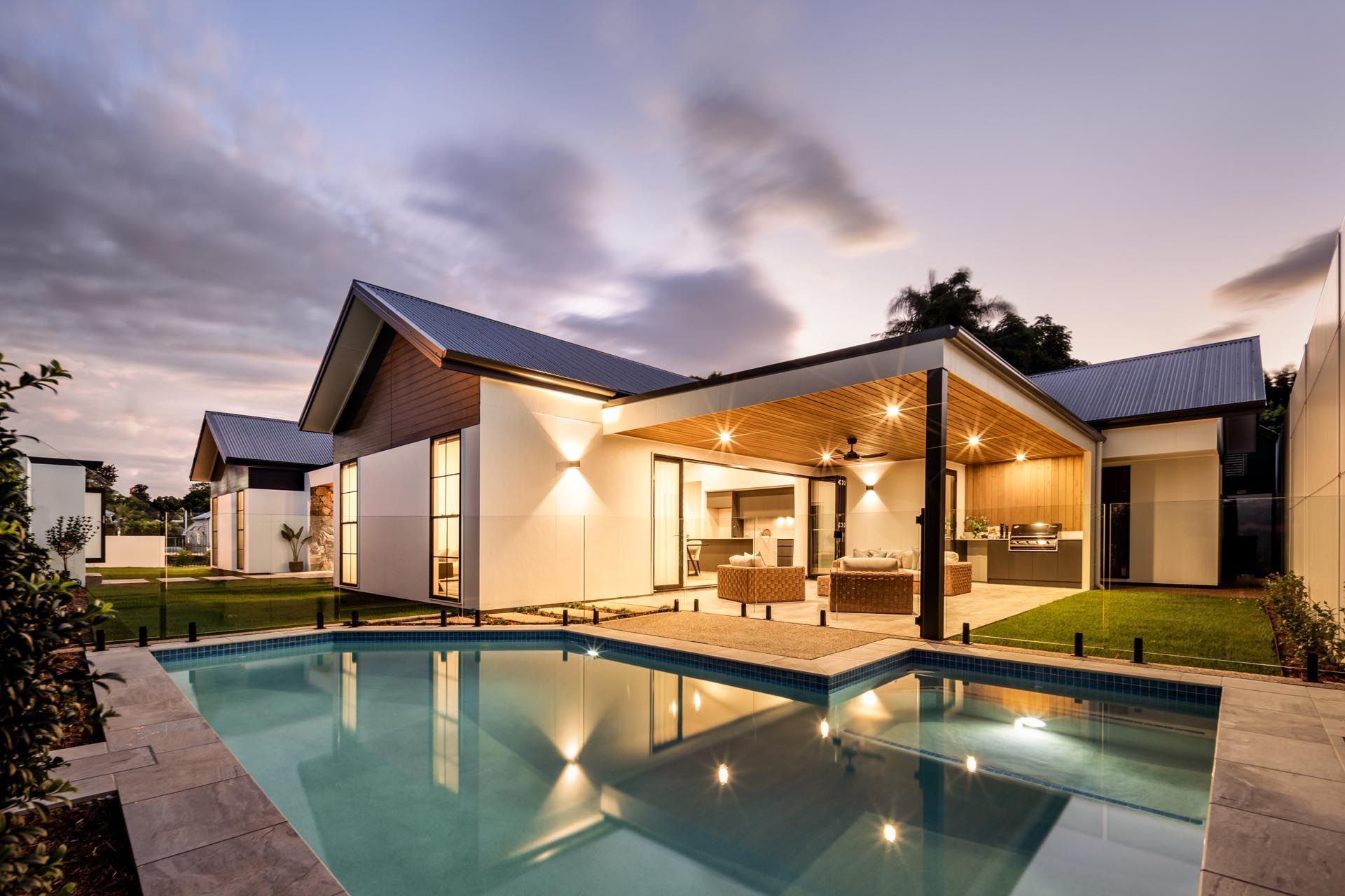 A house with a large swimming pool in front of it.