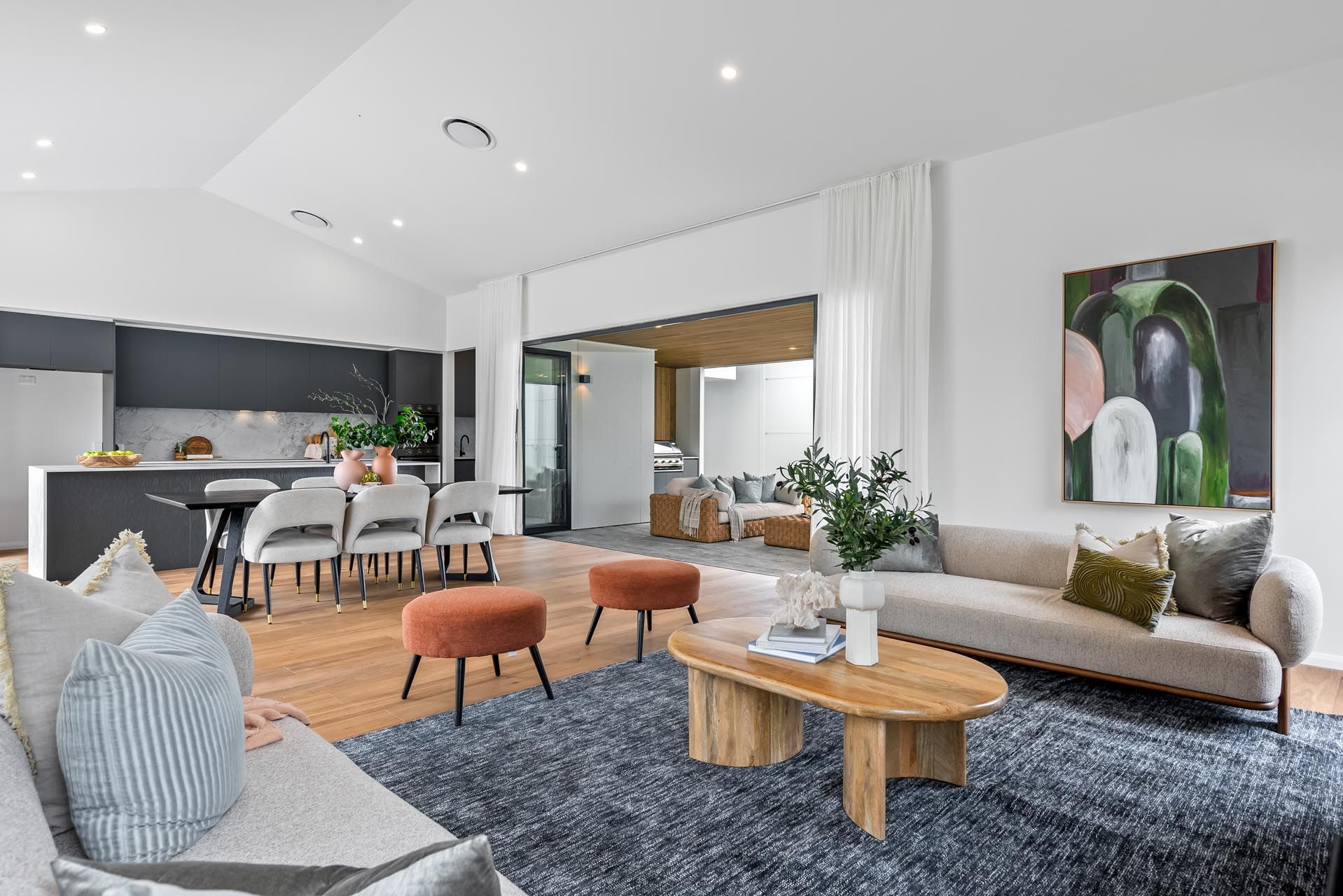 A living room with a couch , table , chairs and a rug.