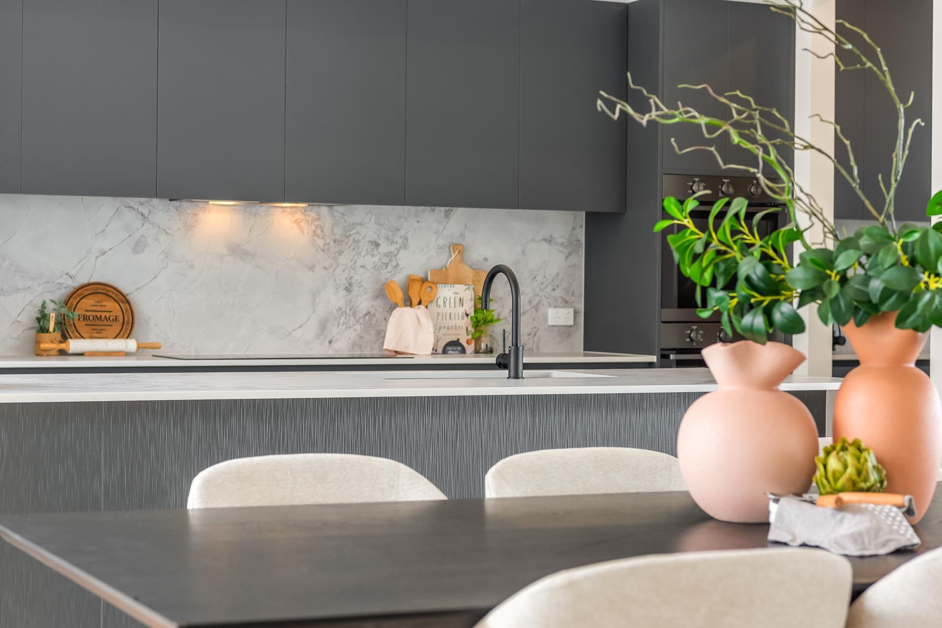 A kitchen with a table and chairs and vases on it.