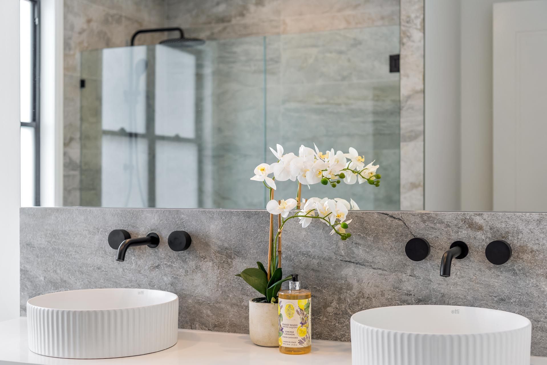 A bathroom with two sinks and a large mirror.