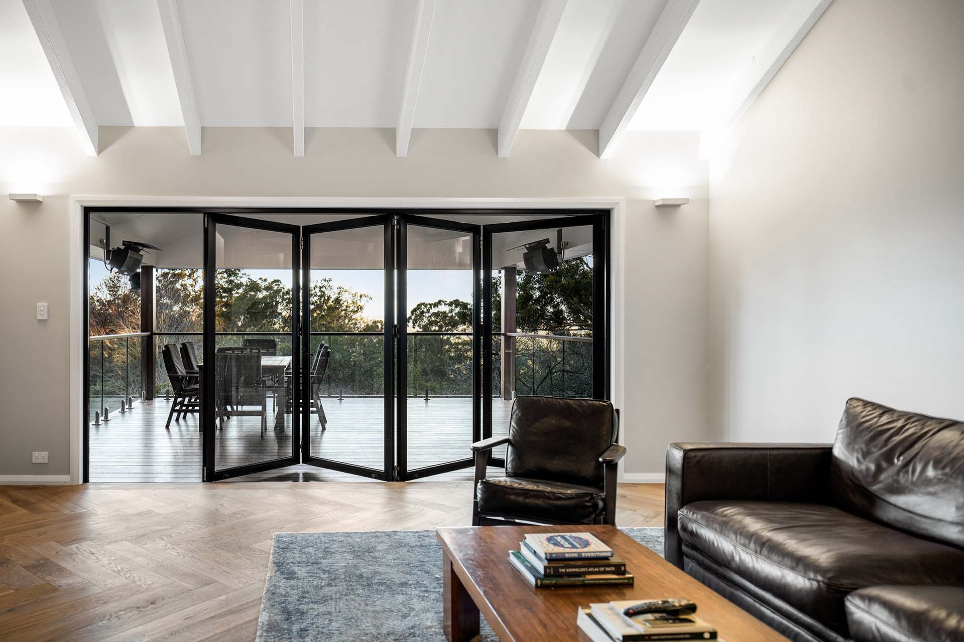 a living room with a couch , chair , coffee table and sliding glass doors .