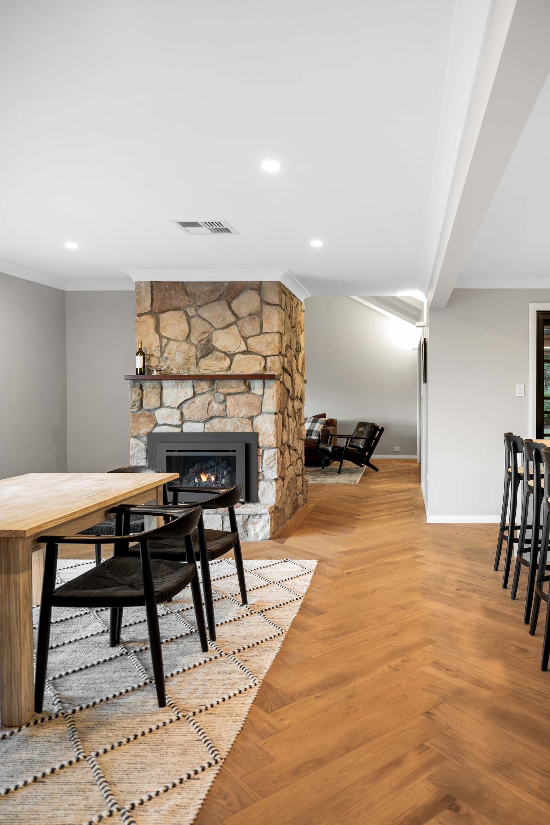 a dining room with a wooden table and chairs and a fireplace .